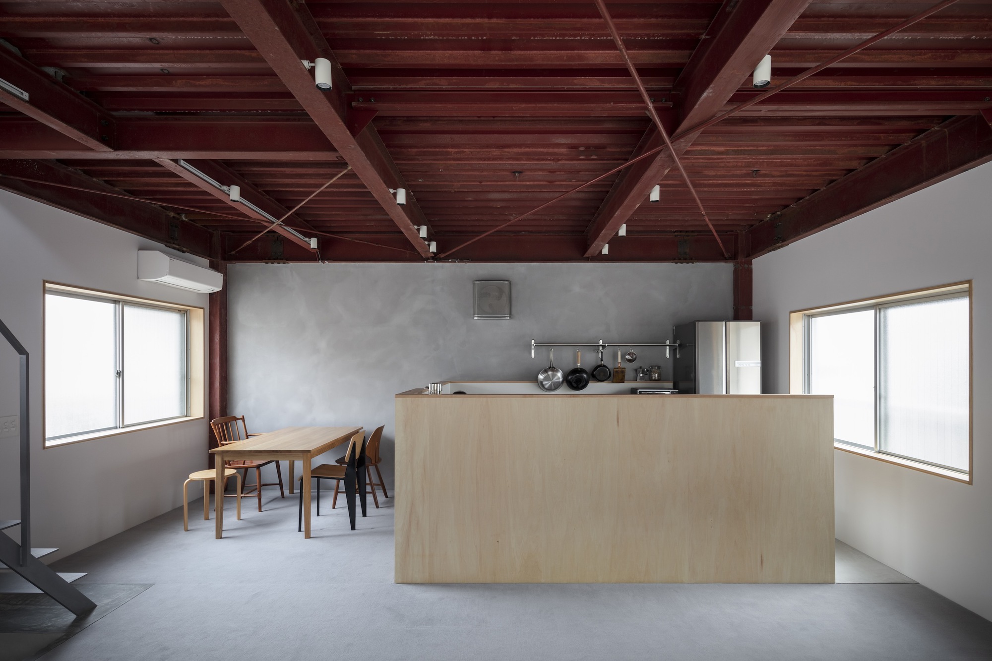 Open kitchen and dining area beneath an exposed dark timber beam ceiling with white walls