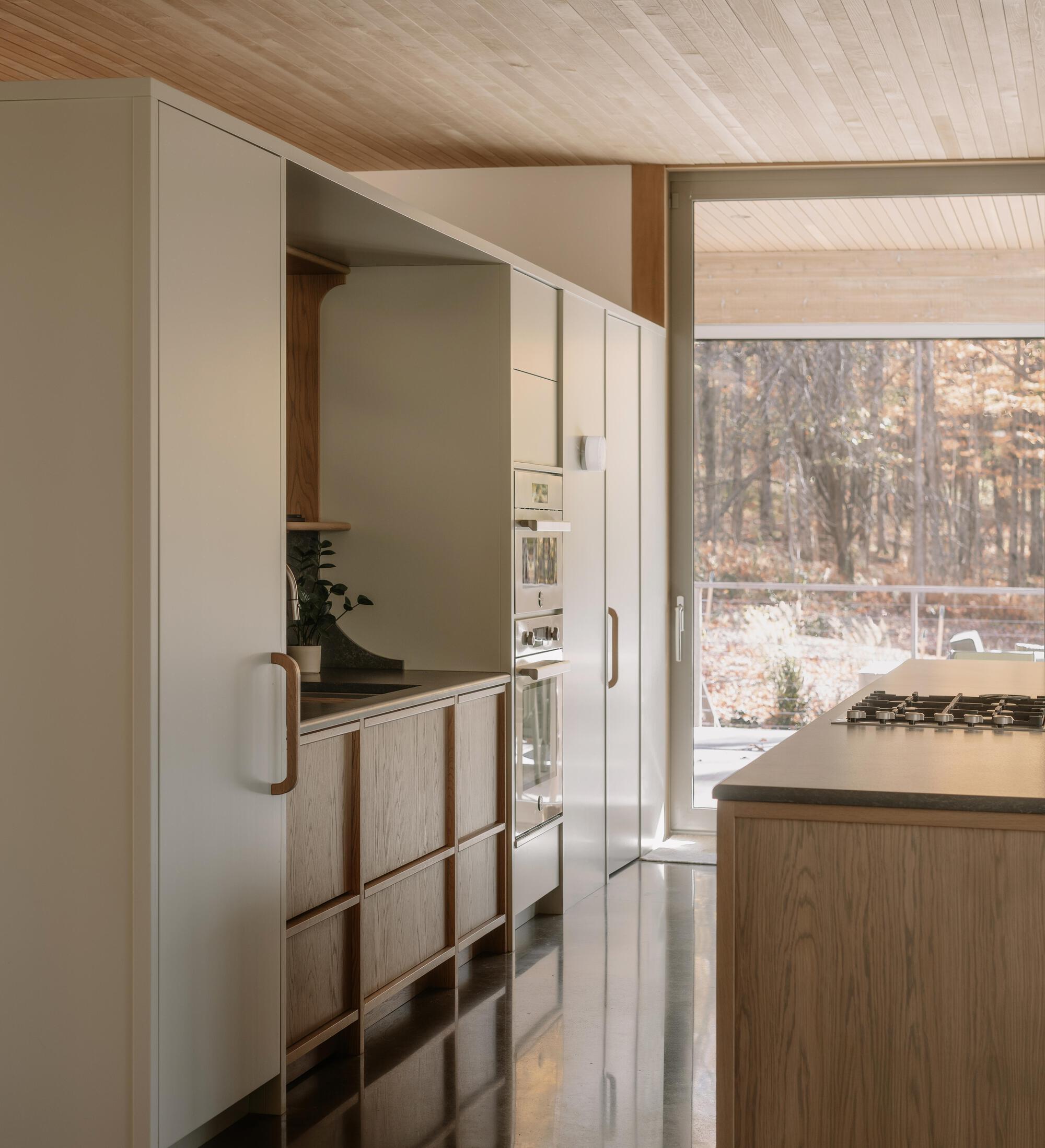 Kitchen with pale cabinetry and timber accents under a tongue-and-groove wood ceiling