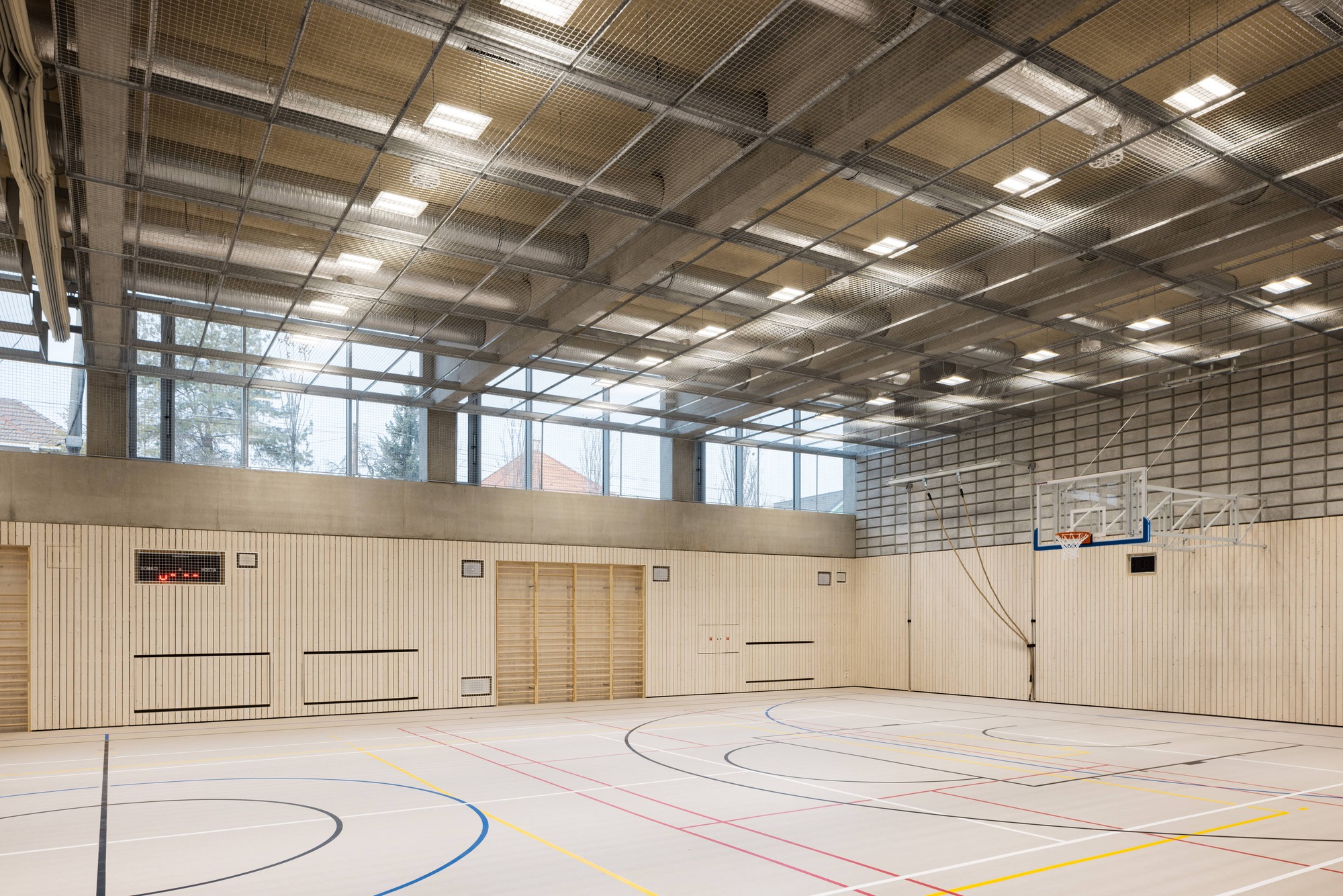 Corner of the sports court with vertical timber wall panels and clerestory glazing above