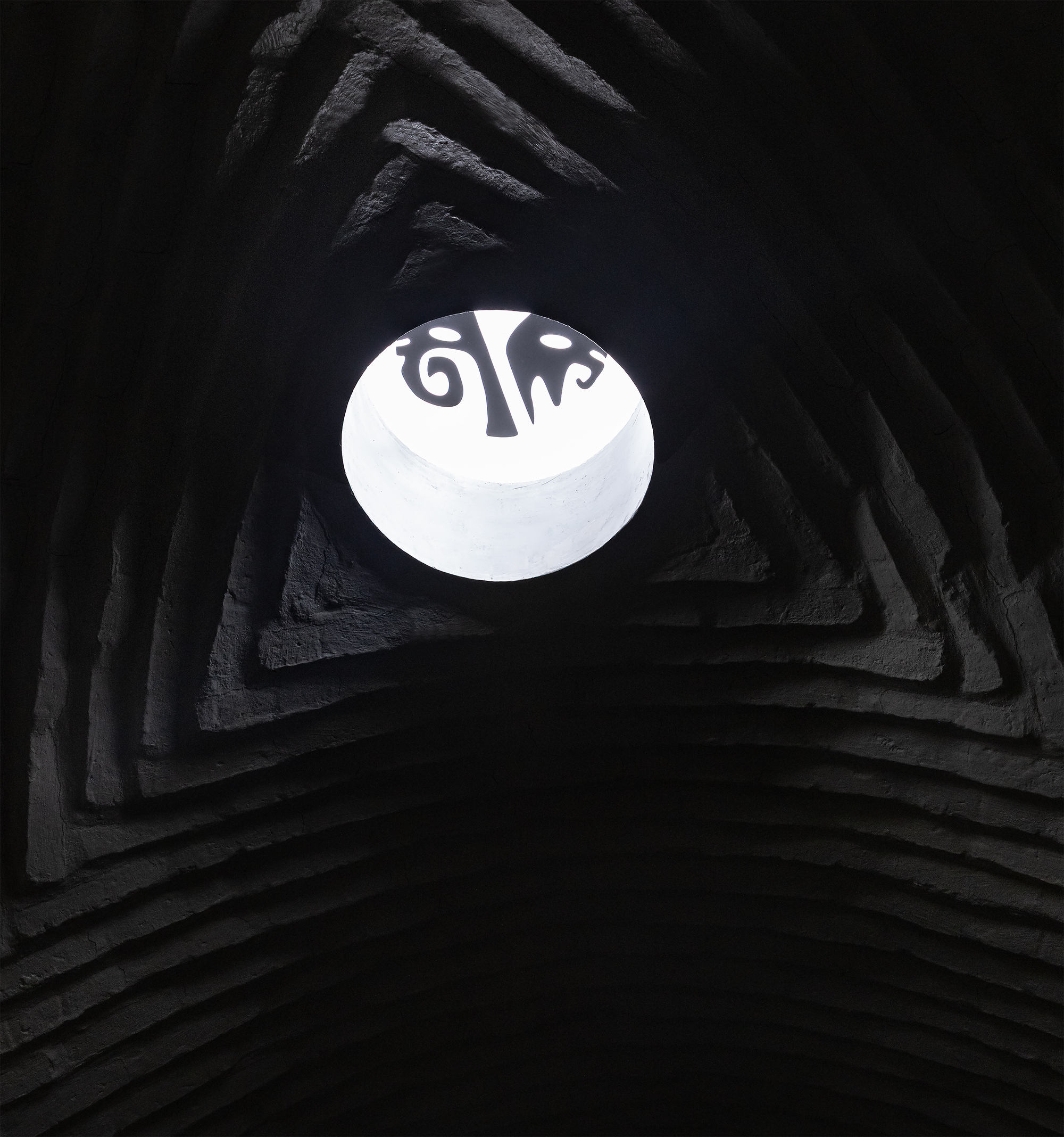 Upward view into pyramidal shaft with circular skylight opening above