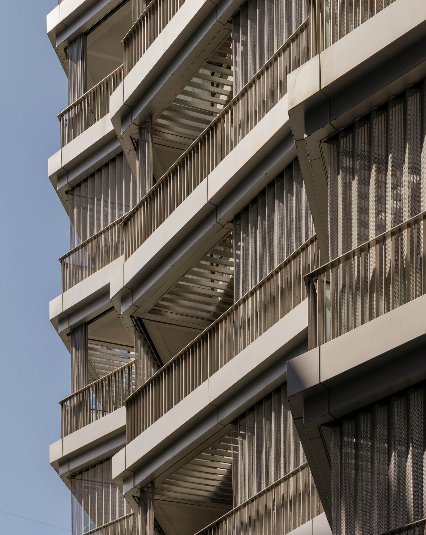 Facade detail showing stacked balconies with vertical timber screening and projecting concrete floor slabs