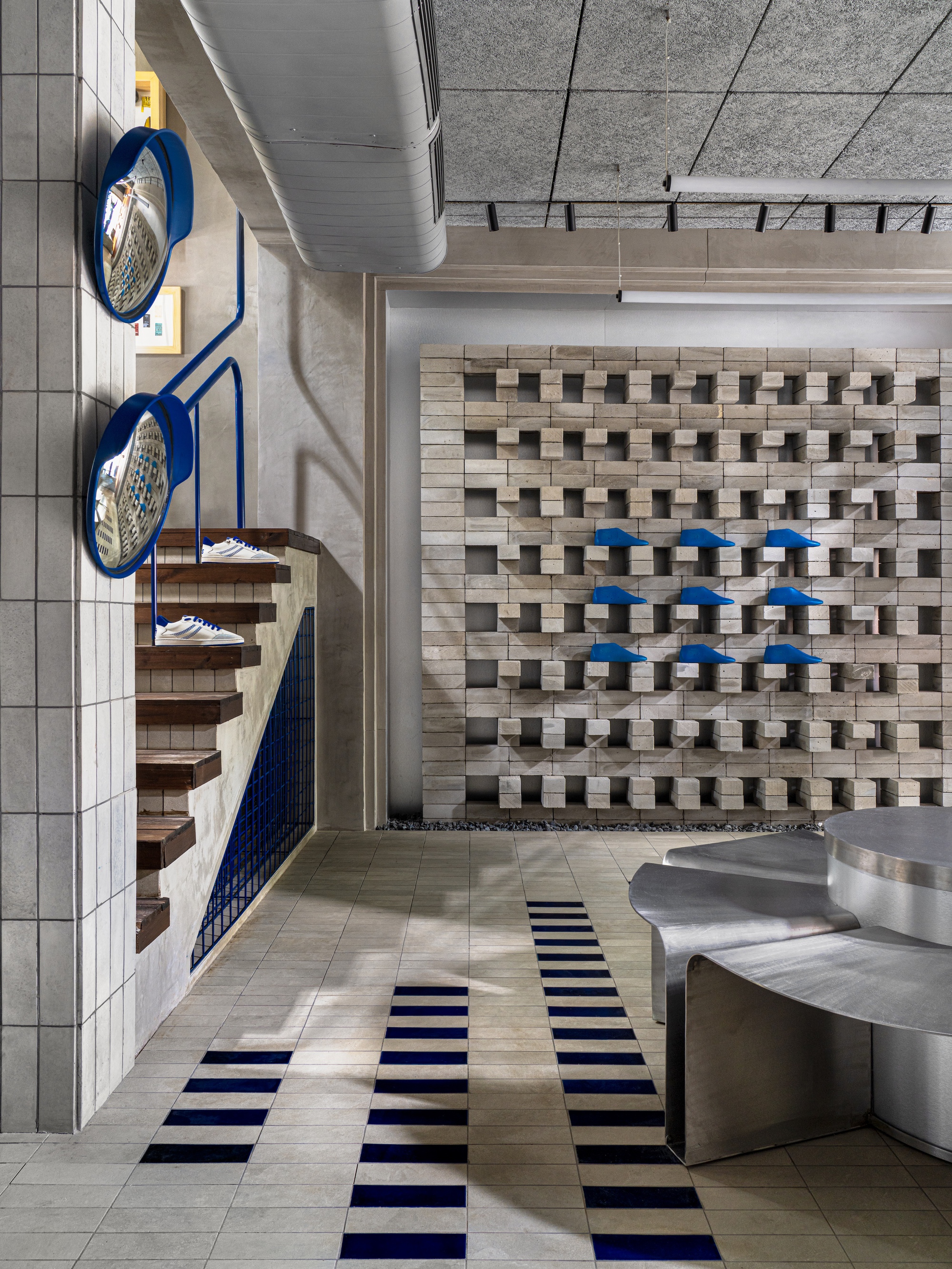 Overhead view showing spiral stair, protruding block wall, and linear floor pattern connecting retail spaces