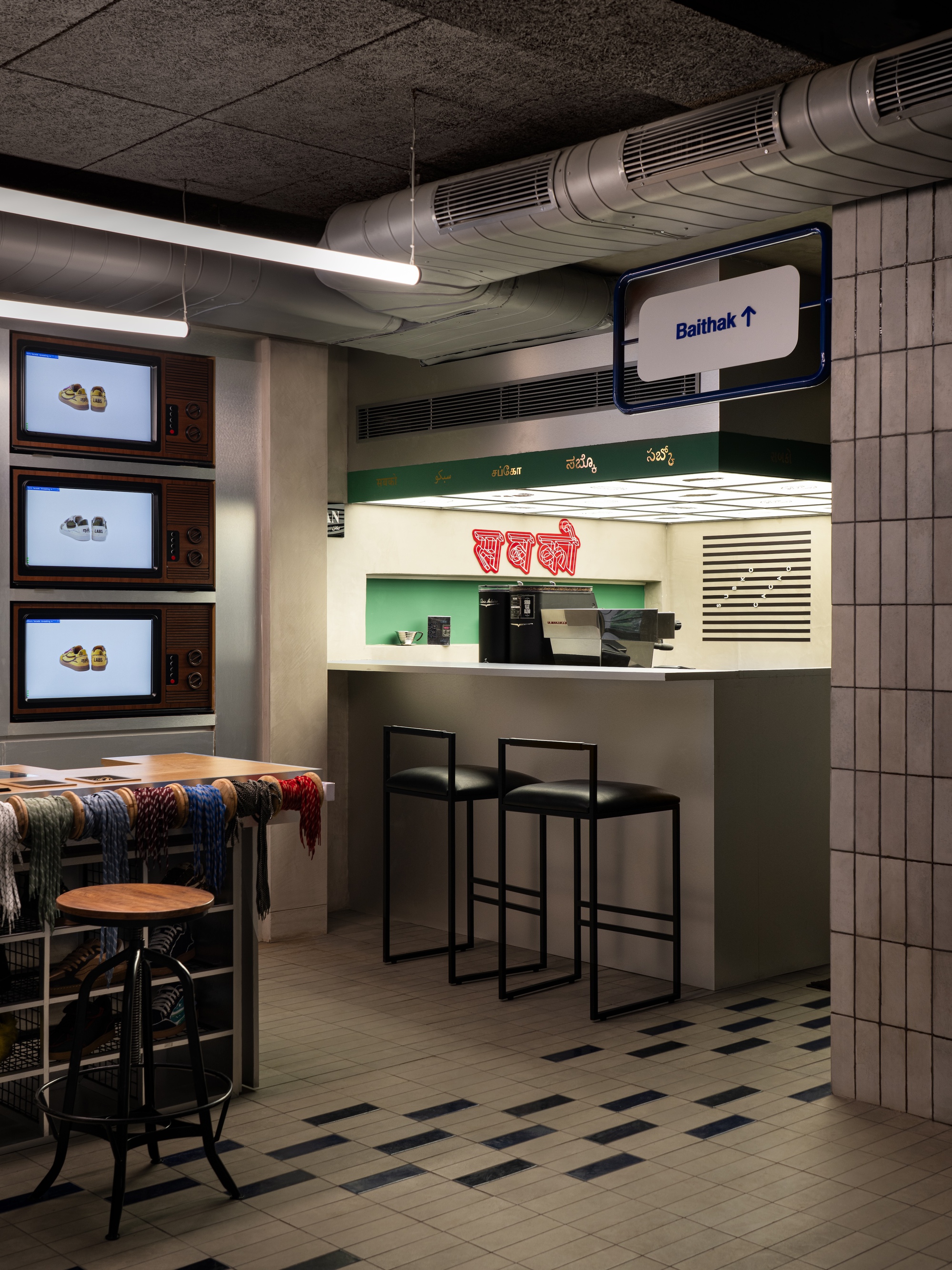 Service counter with illuminated menu panels and exposed ductwork running beneath textured ceiling tiles