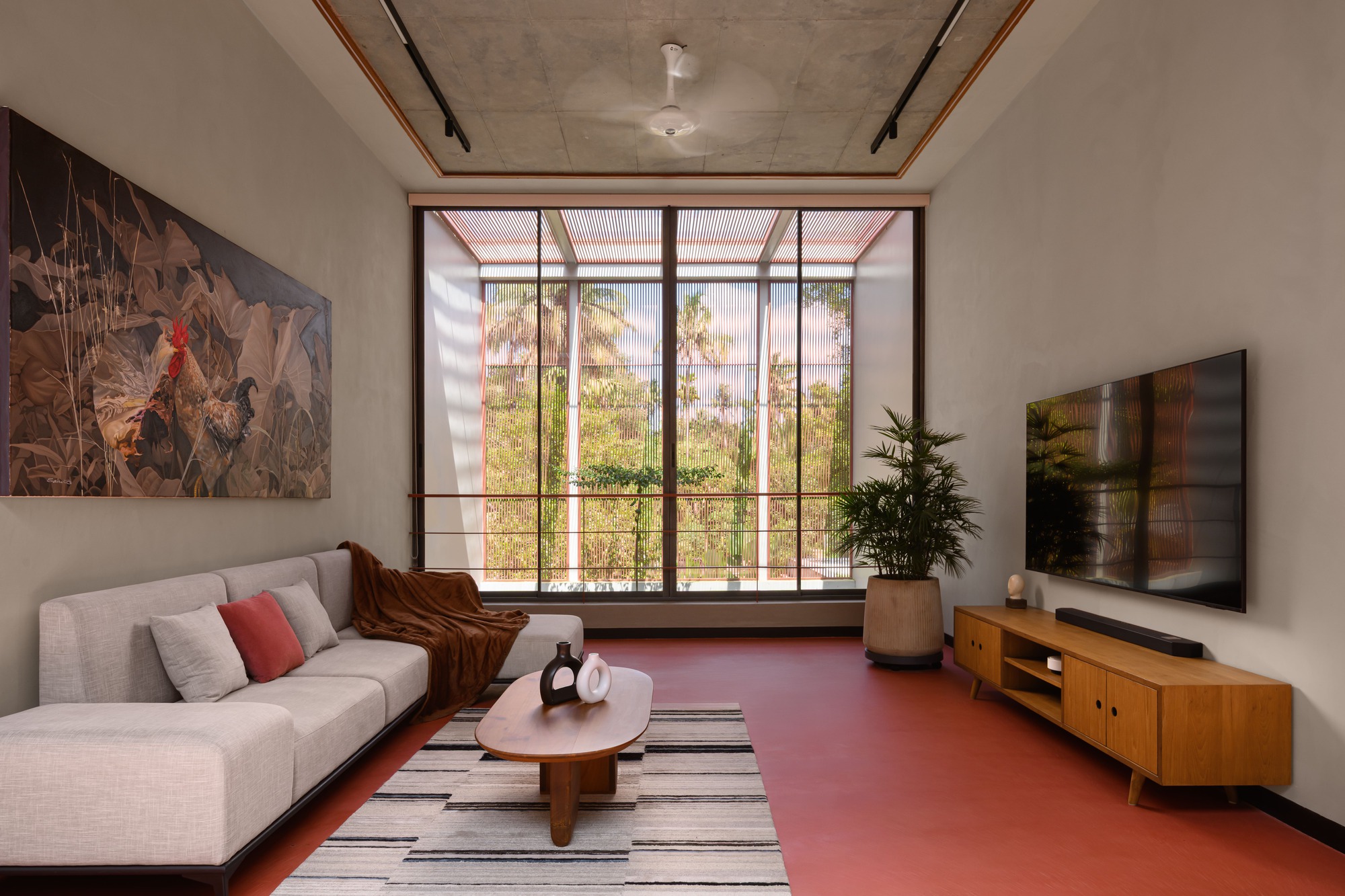 Living room with orange resin floor and full-height window framing the courtyard beyond