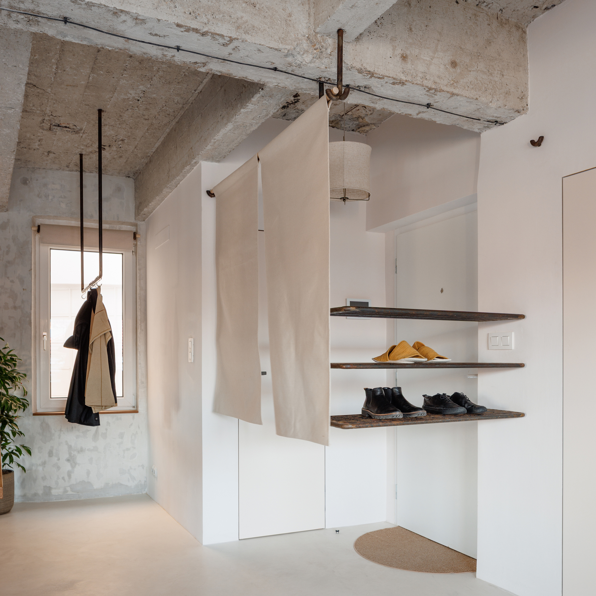 Corner storage niche with floating timber shelves and coat hanging by window opening