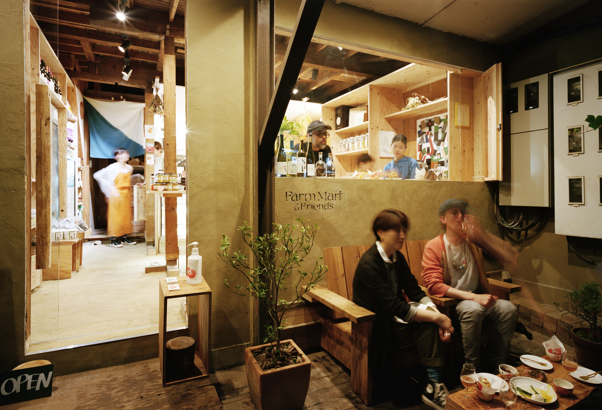 Exposed timber beams and rafters above a seating area with service window and product shelving in background