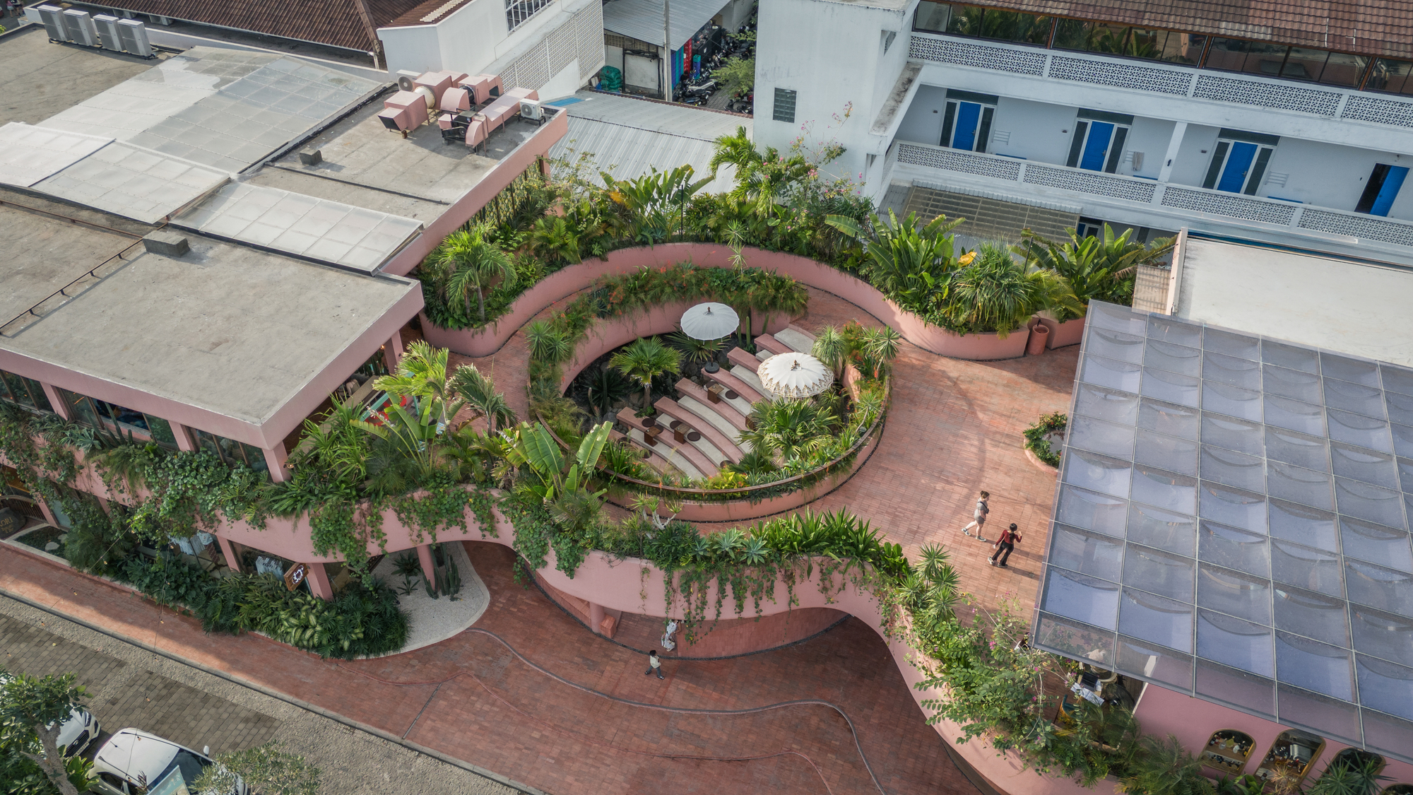 Aerial view of the spiraling rooftop terrace with planted beds and stepped amphitheater seating