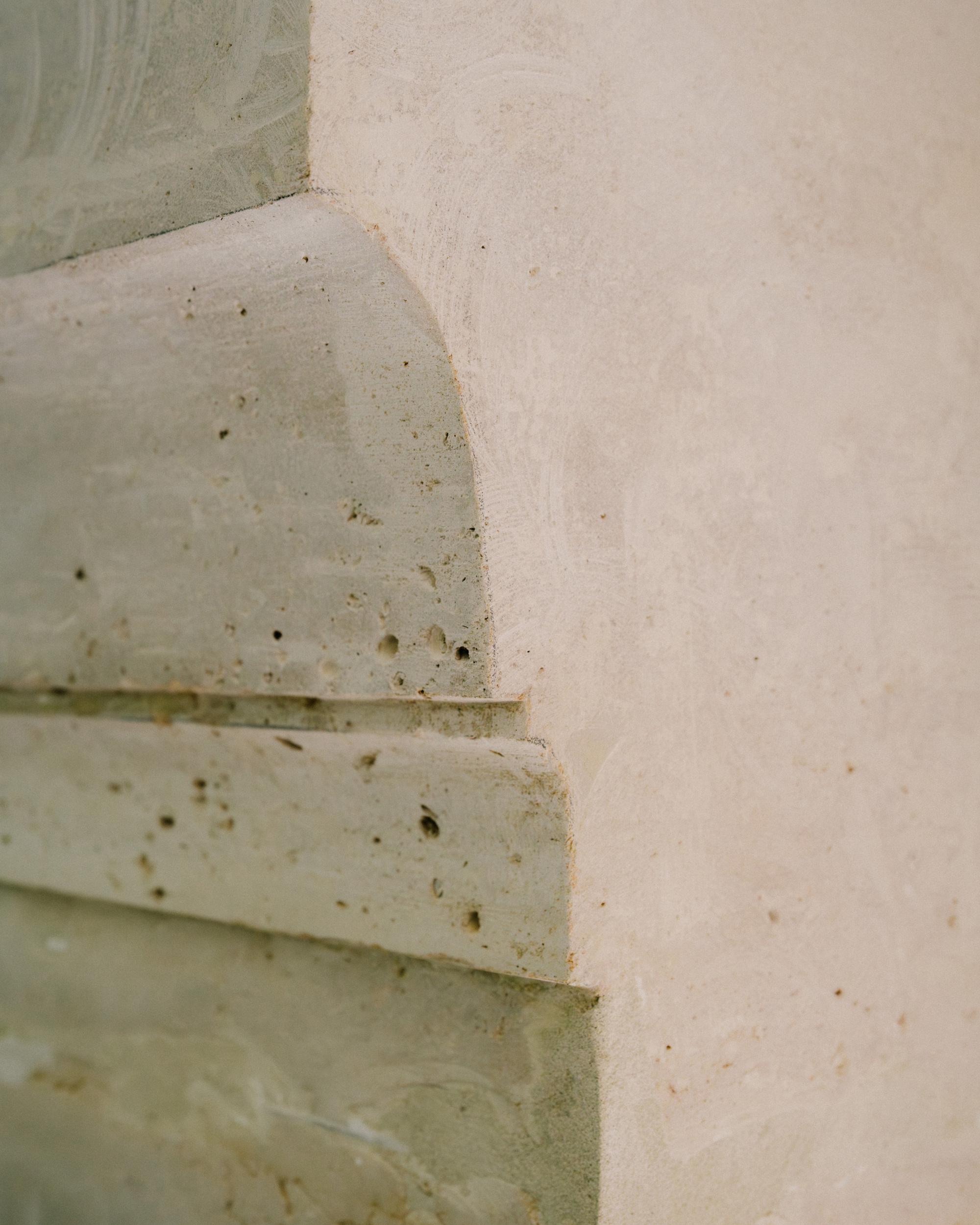 Close-up of curved concrete molding details meeting a plastered corner during construction