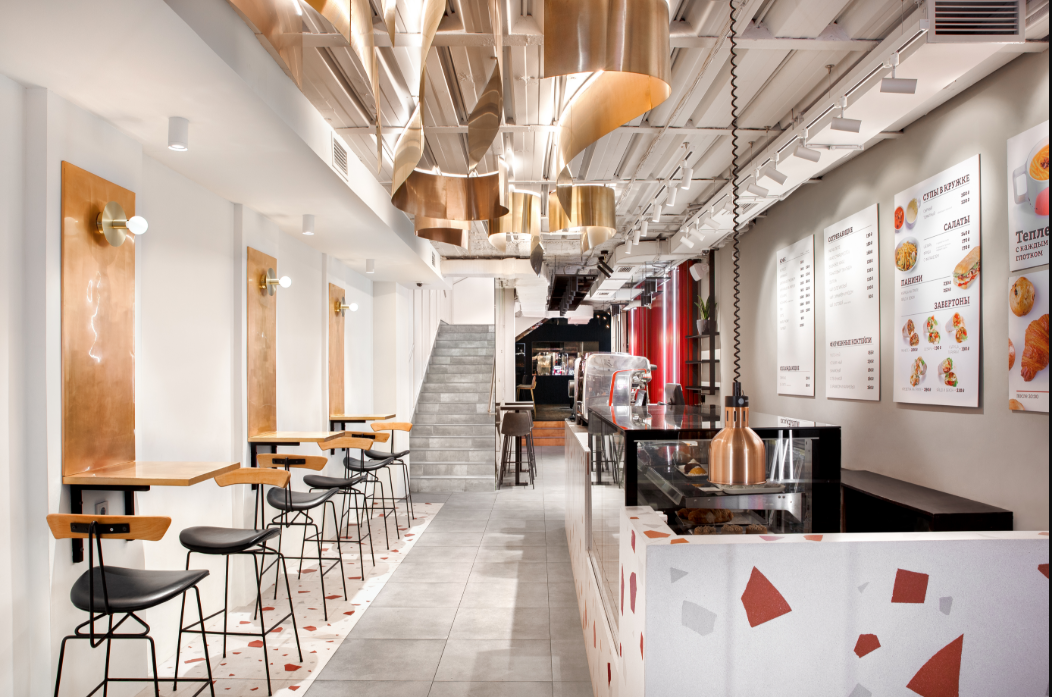 Linear layout with copper ceiling elements guiding spatial flow