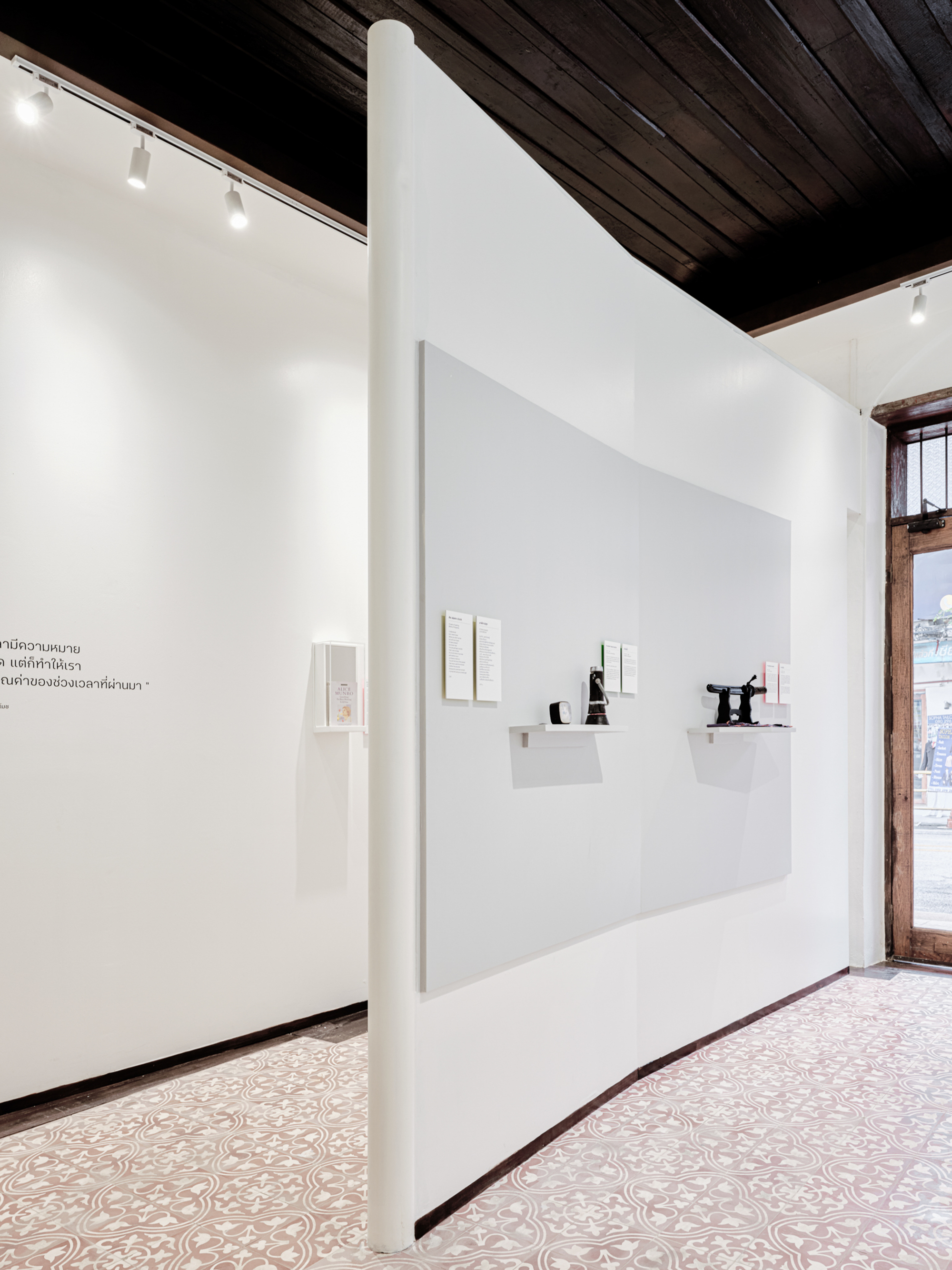 Gallery wall with recessed display niches under exposed timber ceiling beams and track lighting