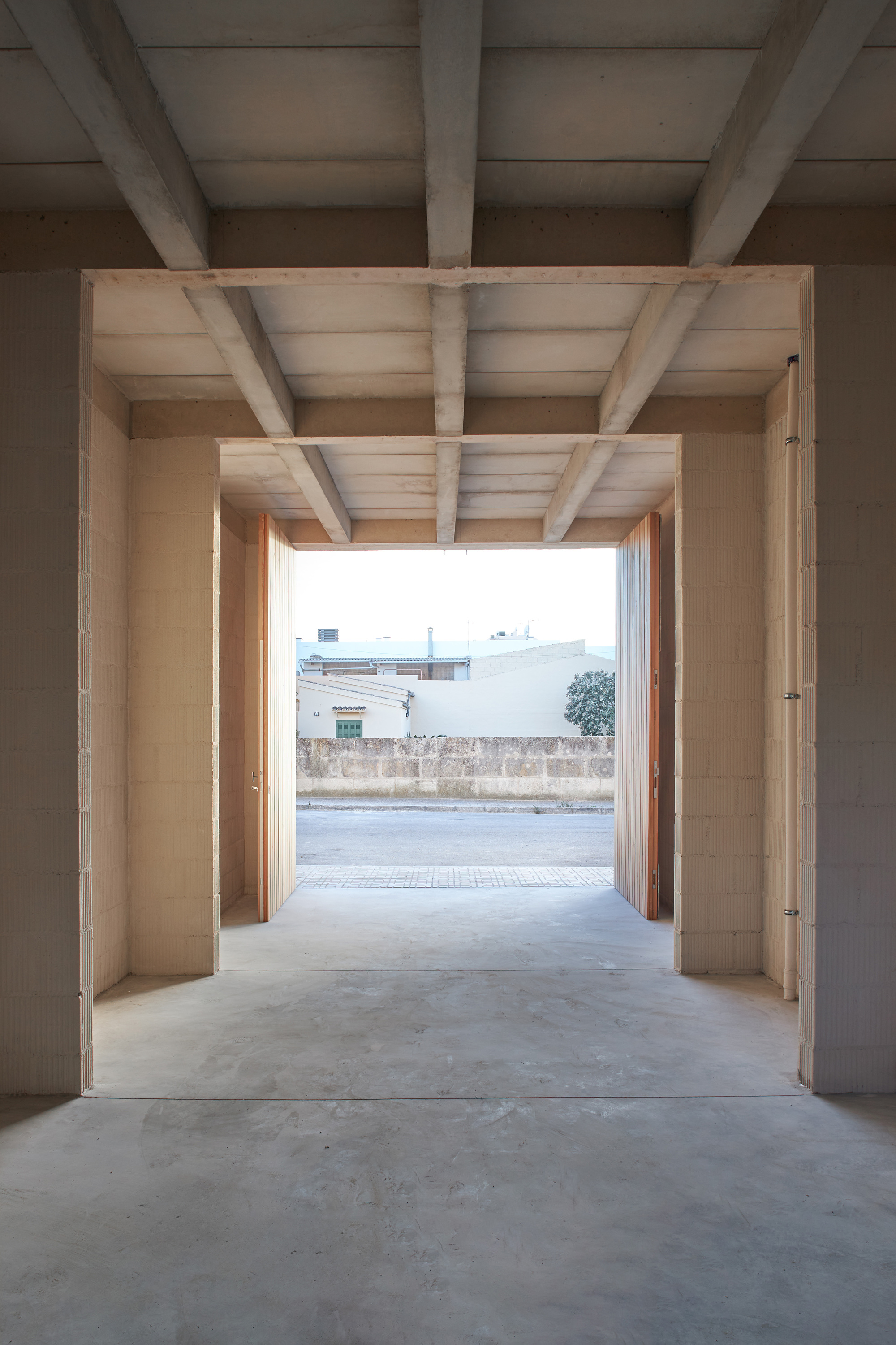 Entry passage framed by exposed timber beams and joists opening onto the street