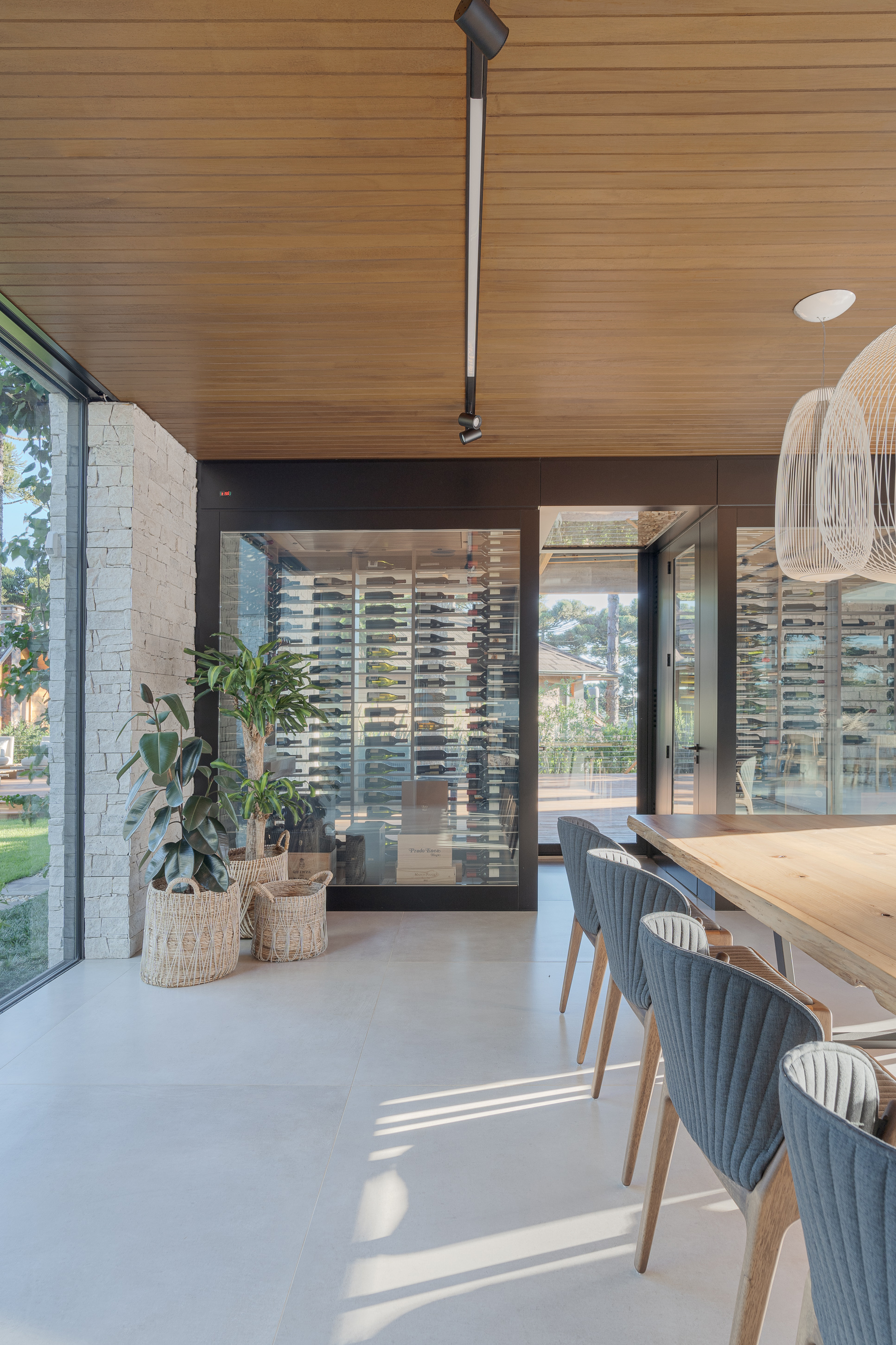 Corner threshold between interior dining area and outdoor terrace with white brick wall and potted plants