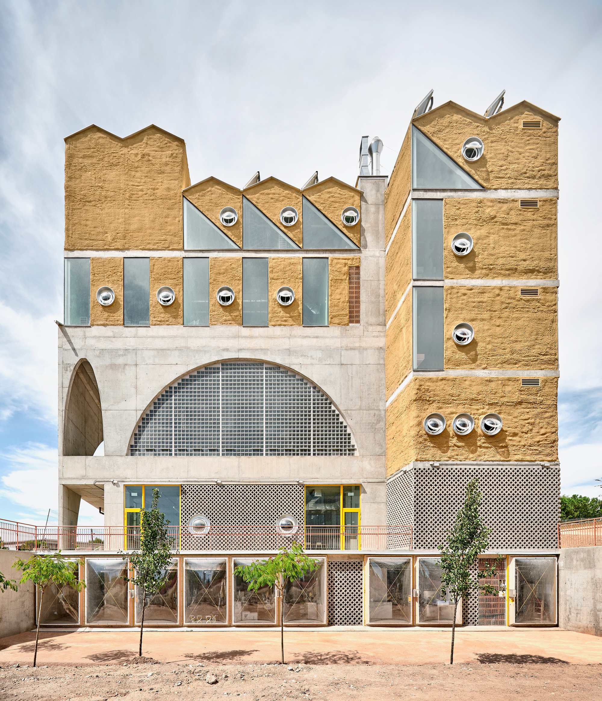 Facade detail showing arched concrete base, alternating brick and glass panels, and glazed ground level planters