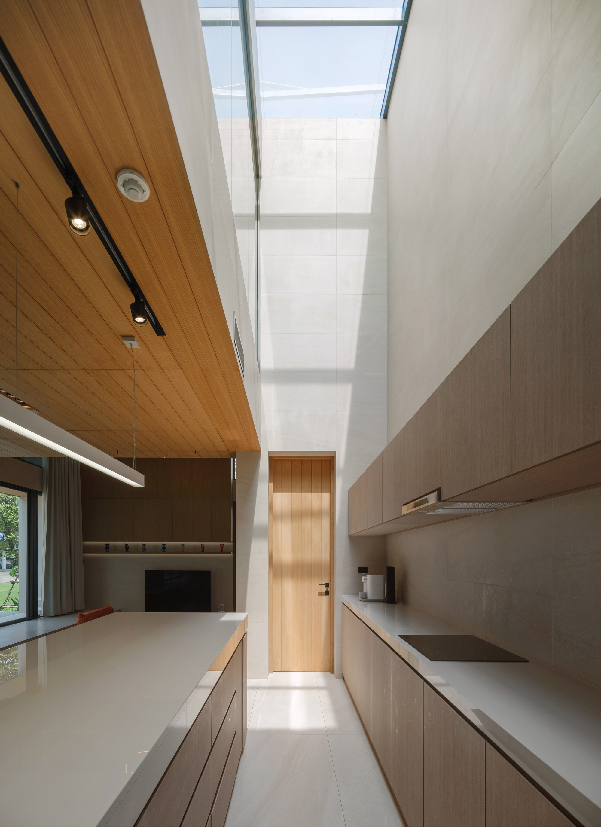 Kitchen interior with skylight overhead and timber door visible at the corridor's end