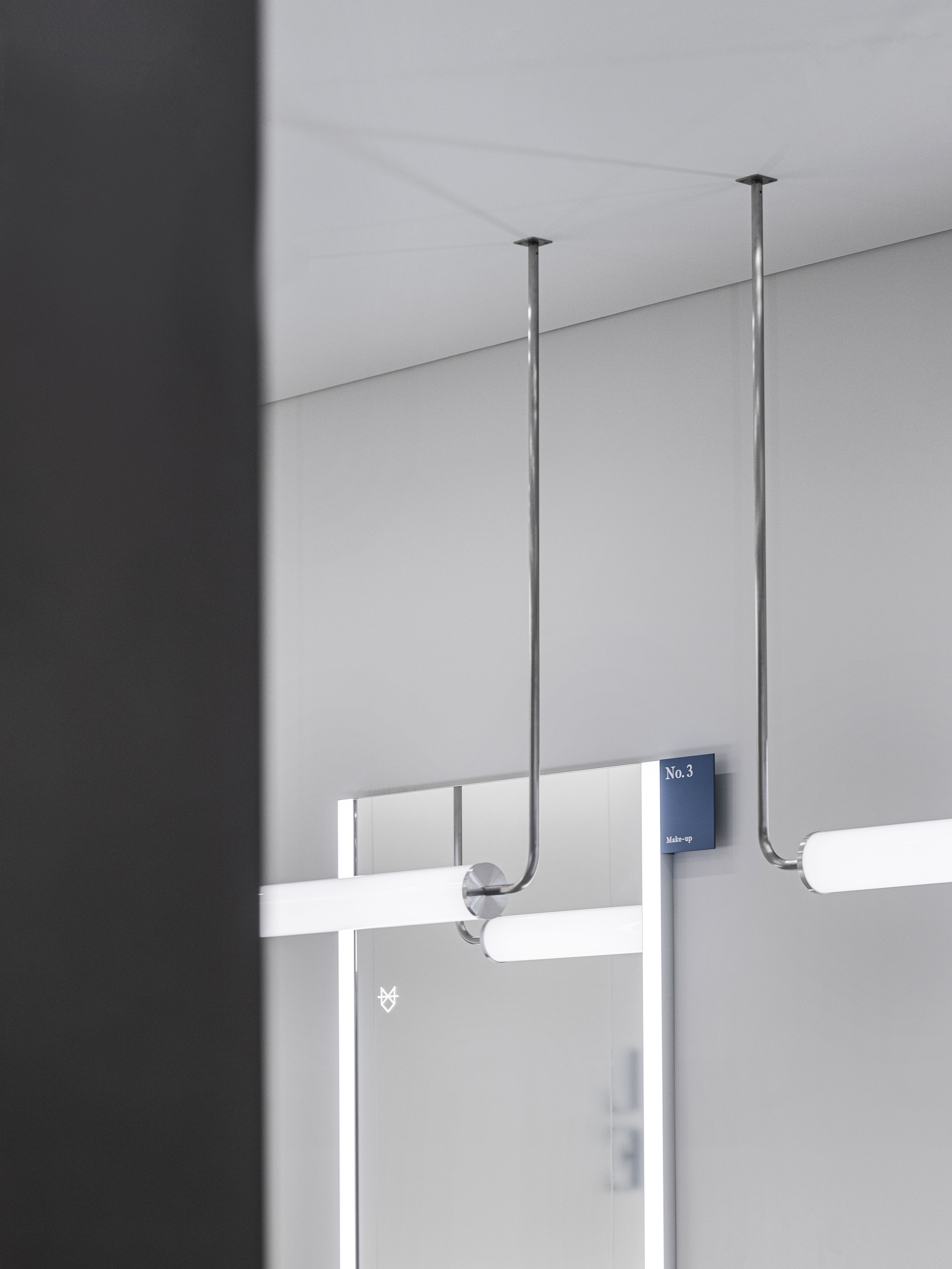 Detail of ceiling-mounted rod suspension system with numbered signage on translucent glass partition