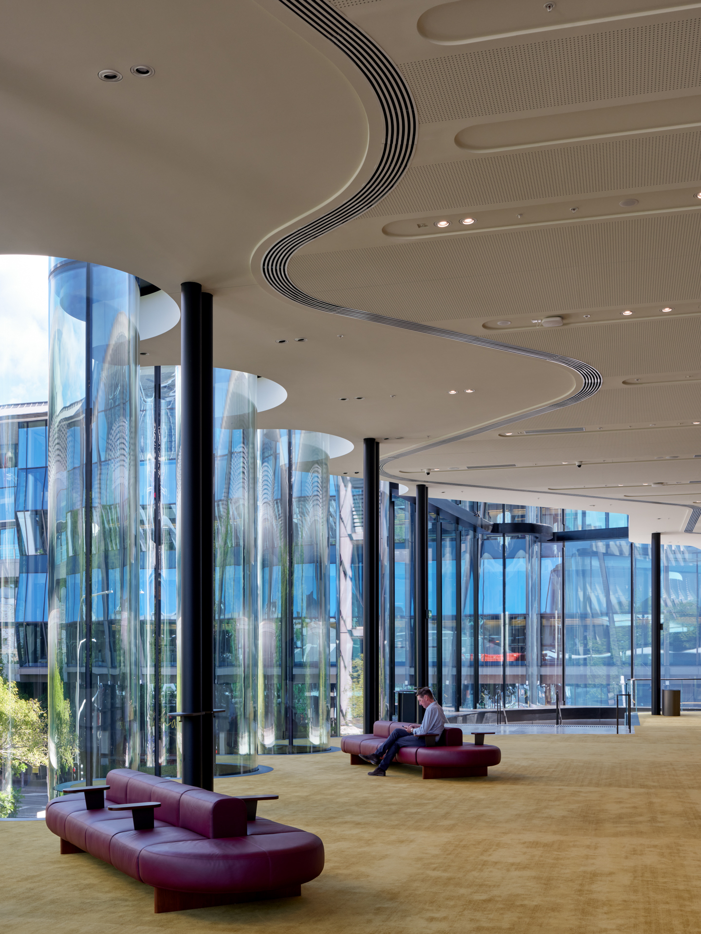 Interior showing the ribbed ceiling detail with circular light wells beside the glazed cylindrical facade columns