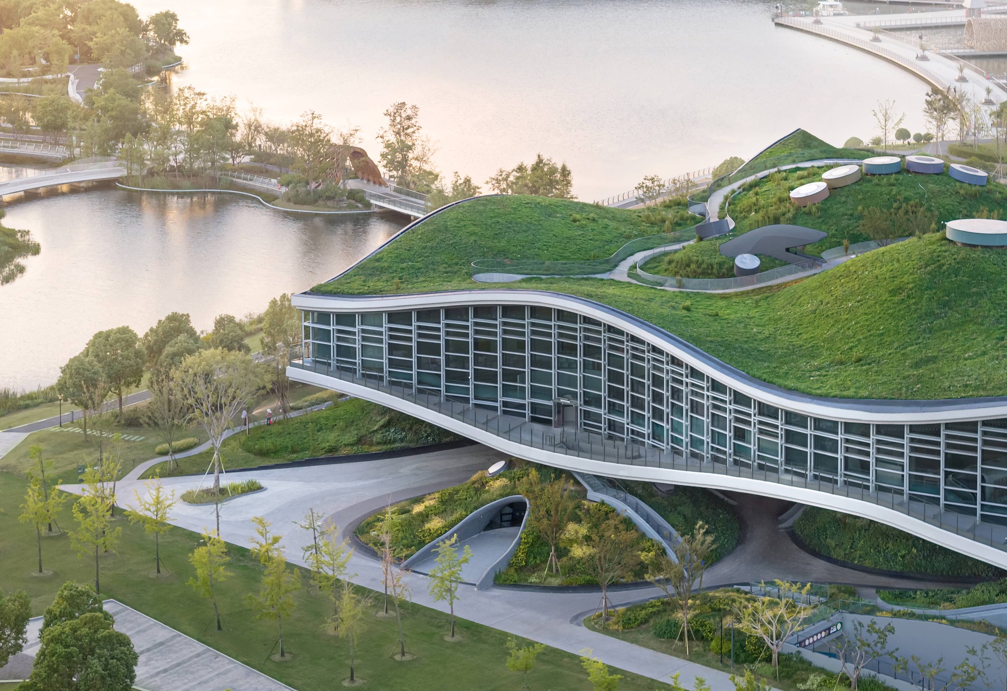 Aerial view of the grass-covered roof with circular skylights and curved pathways through the landscape