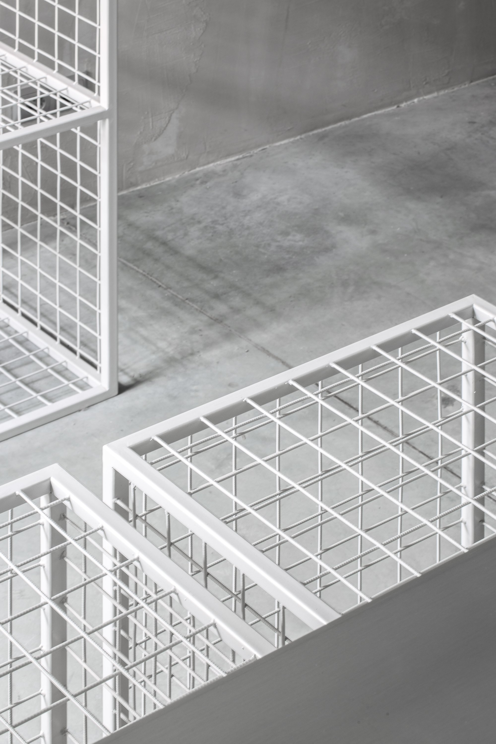 Close-up of white steel grid display units highlighting material precision and texture.