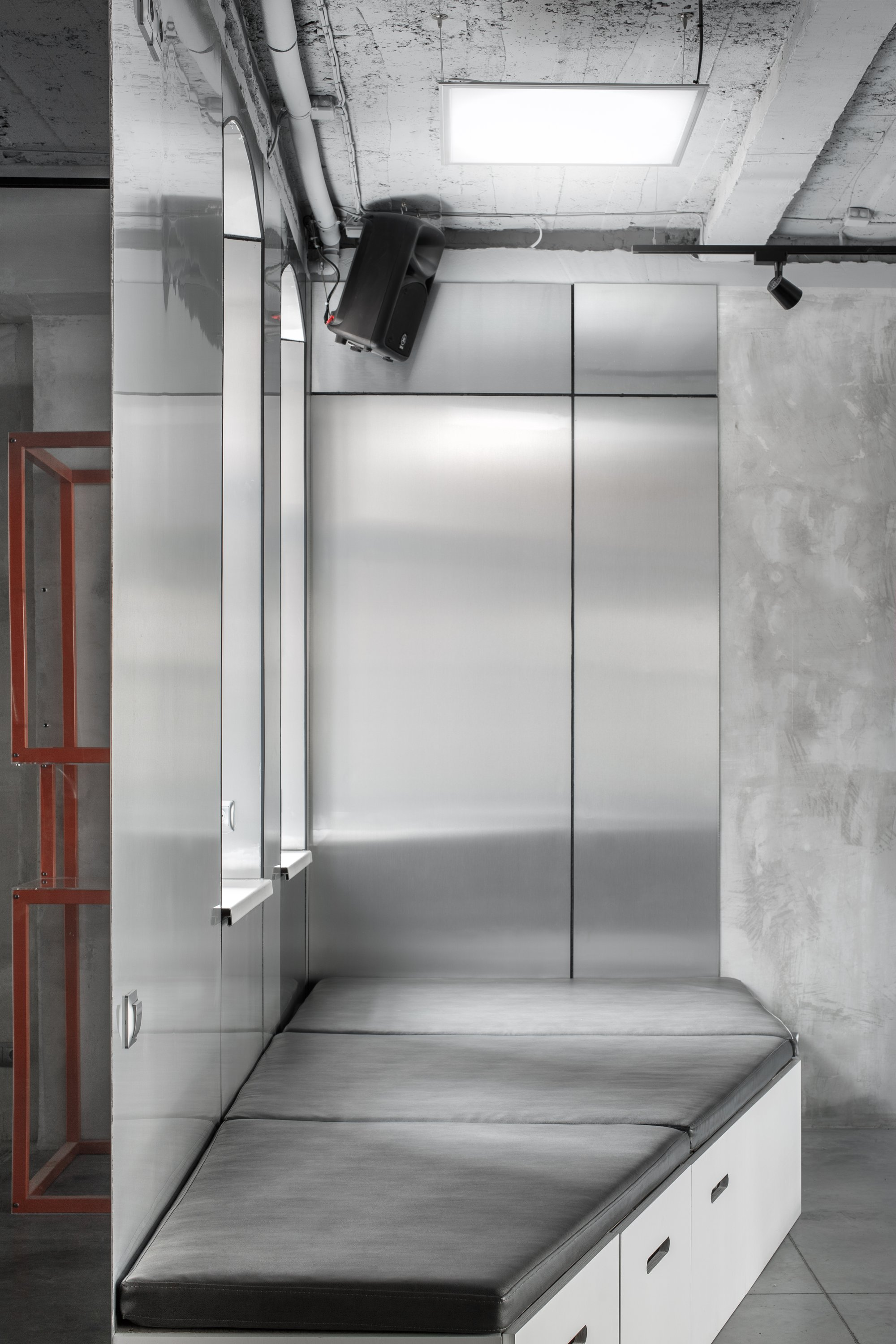Monochrome interior with integrated seating and concealed storage for multifunctional use.