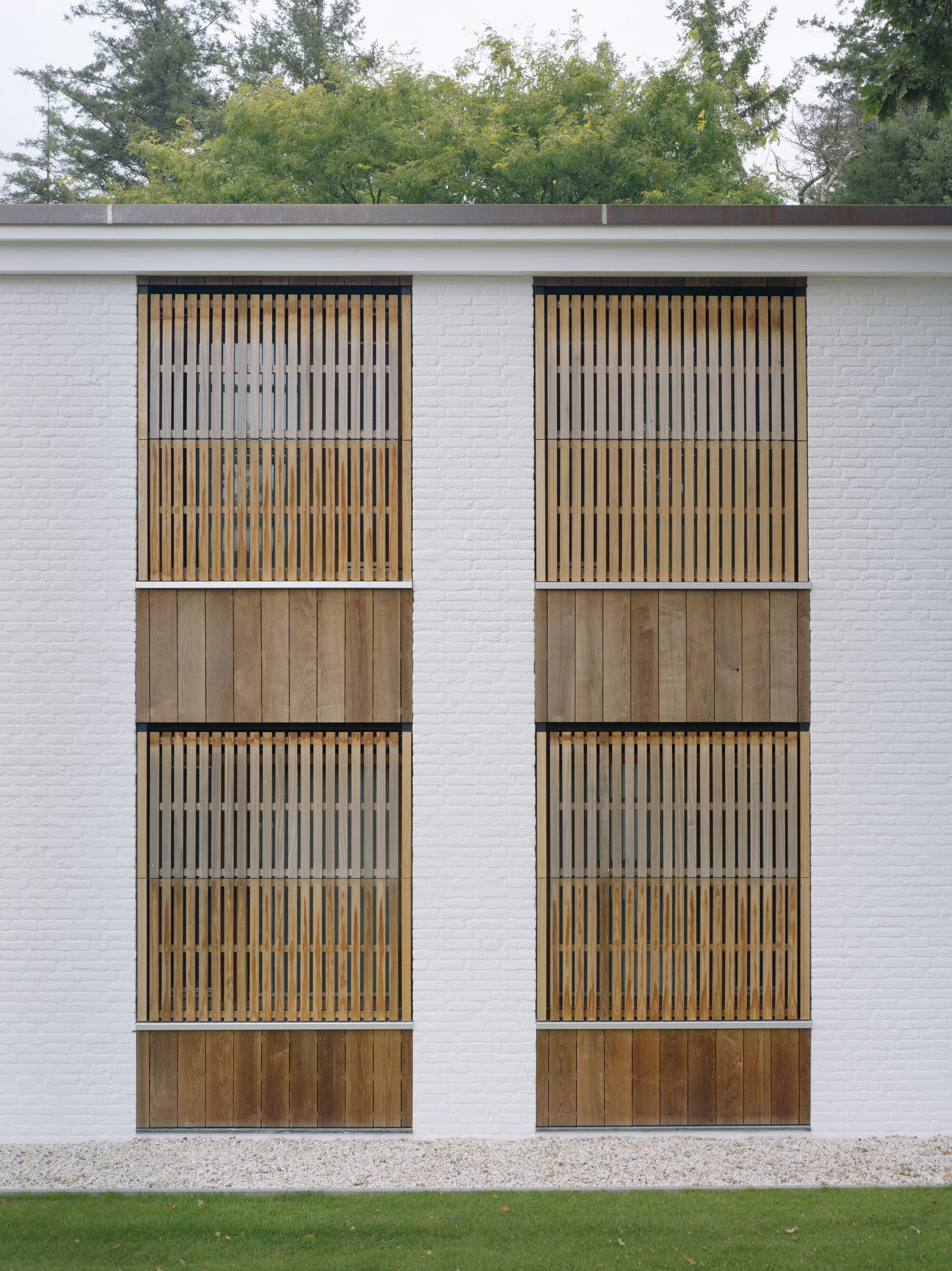 Close-up of paired timber balconies with vertical slat screens and solid panel bases