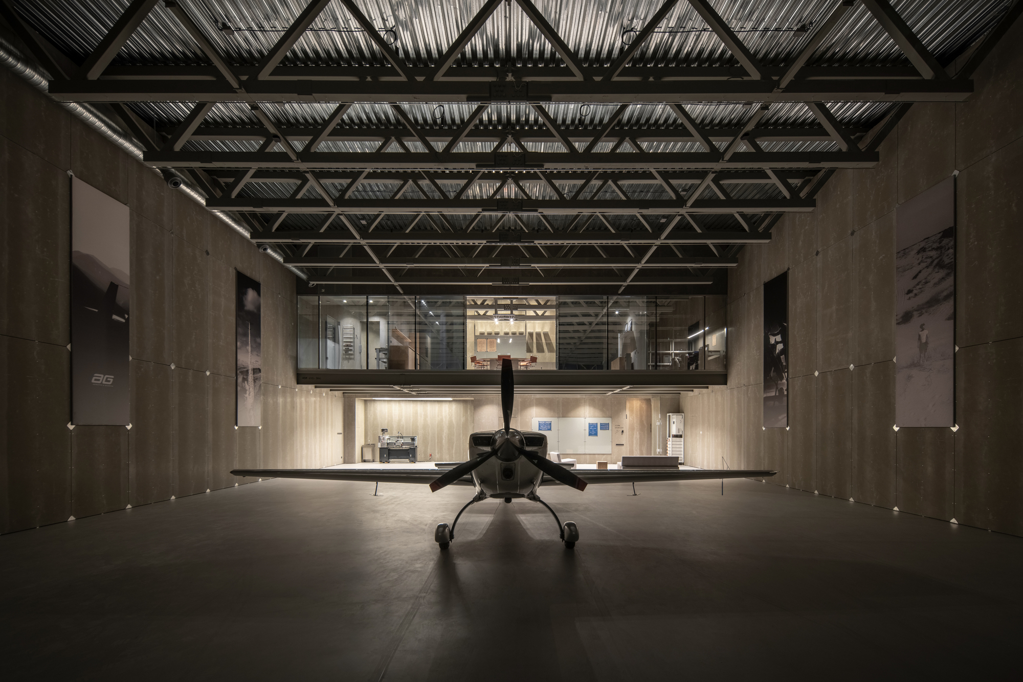 Tail view of aircraft centered in the hangar with mezzanine level visible at the rear