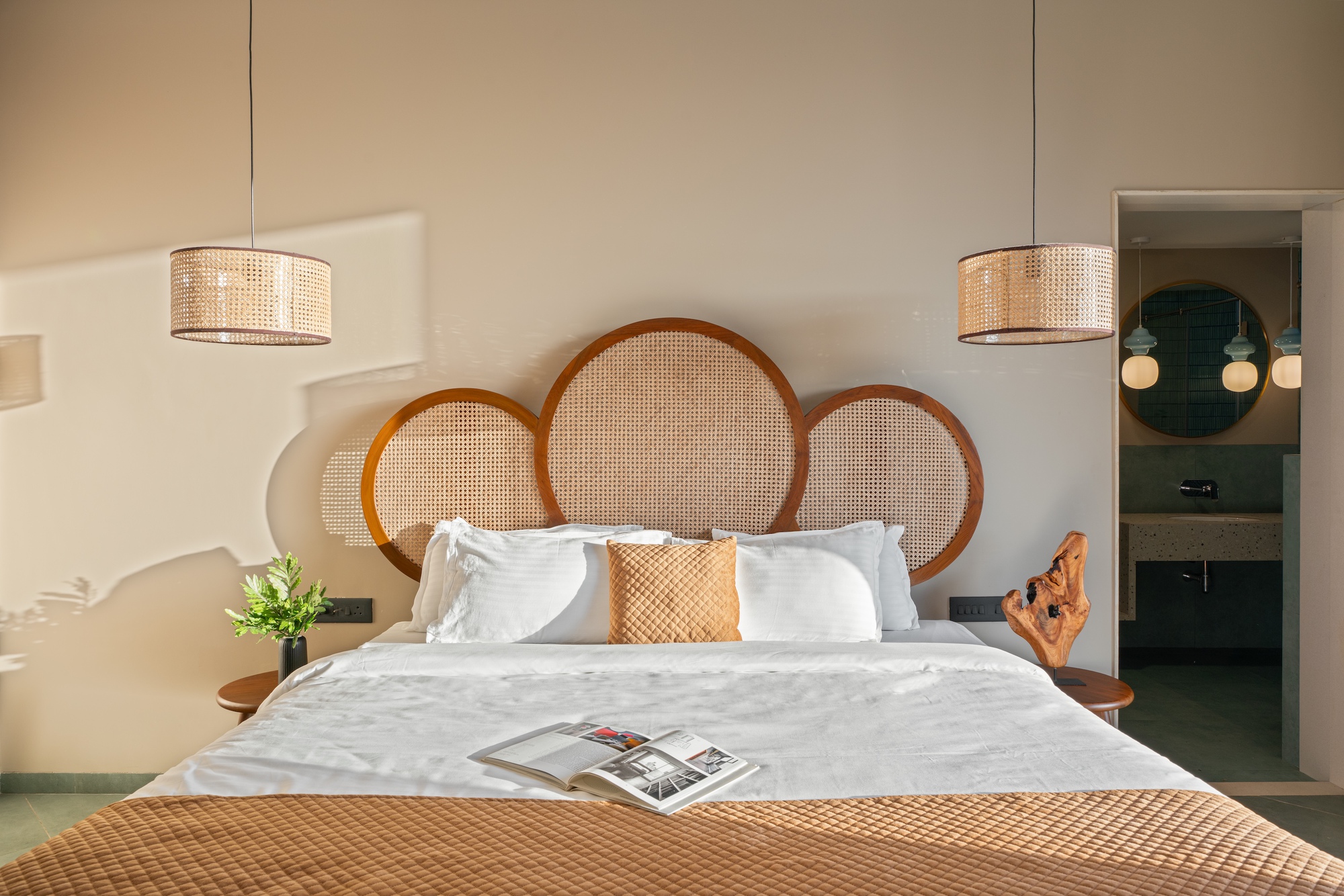 Bedroom with circular cane headboard panels and doorway leading to the ensuite bathroom