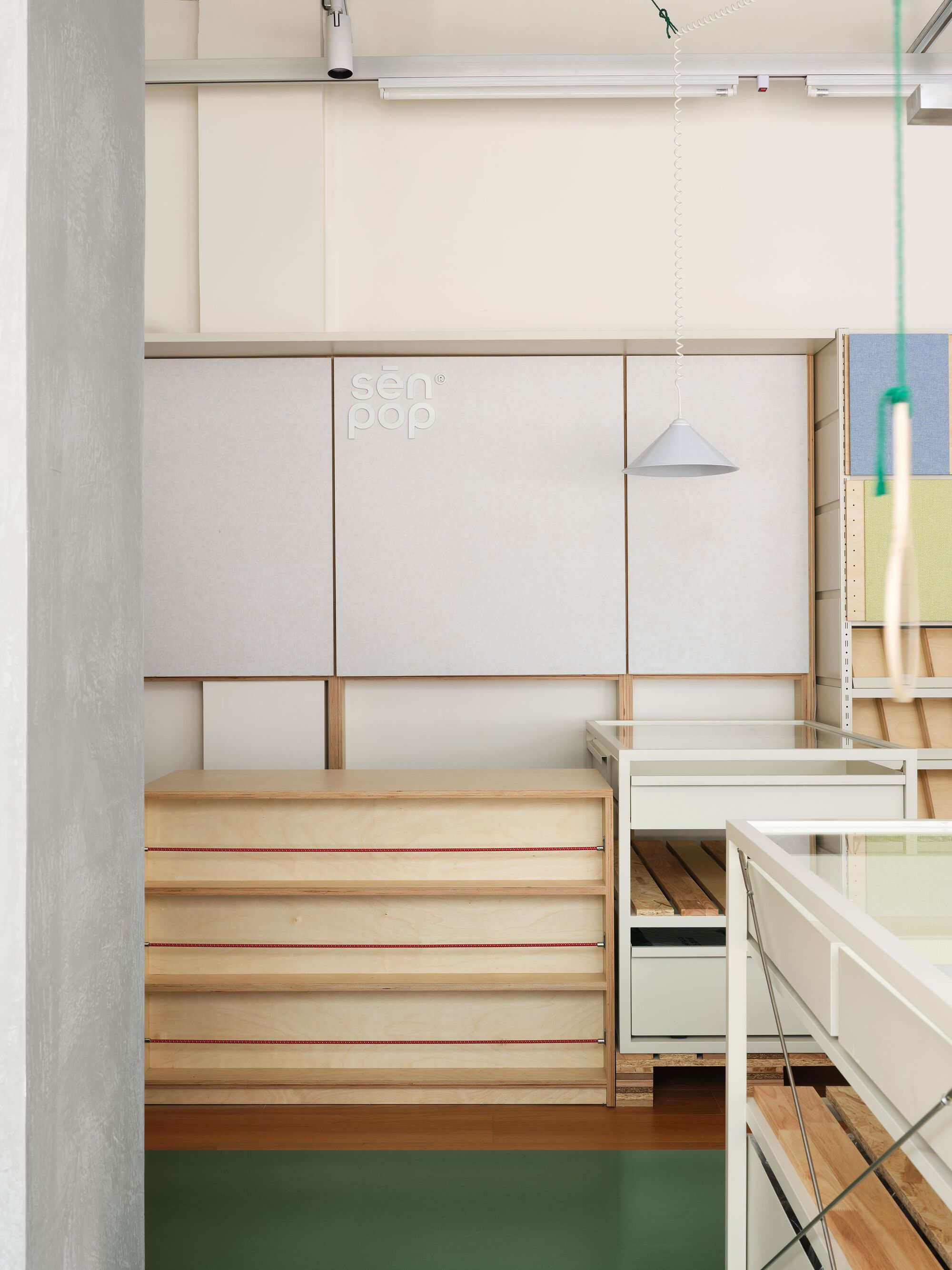 Timber bench with red edge detail beneath white sliding panels and pendant light