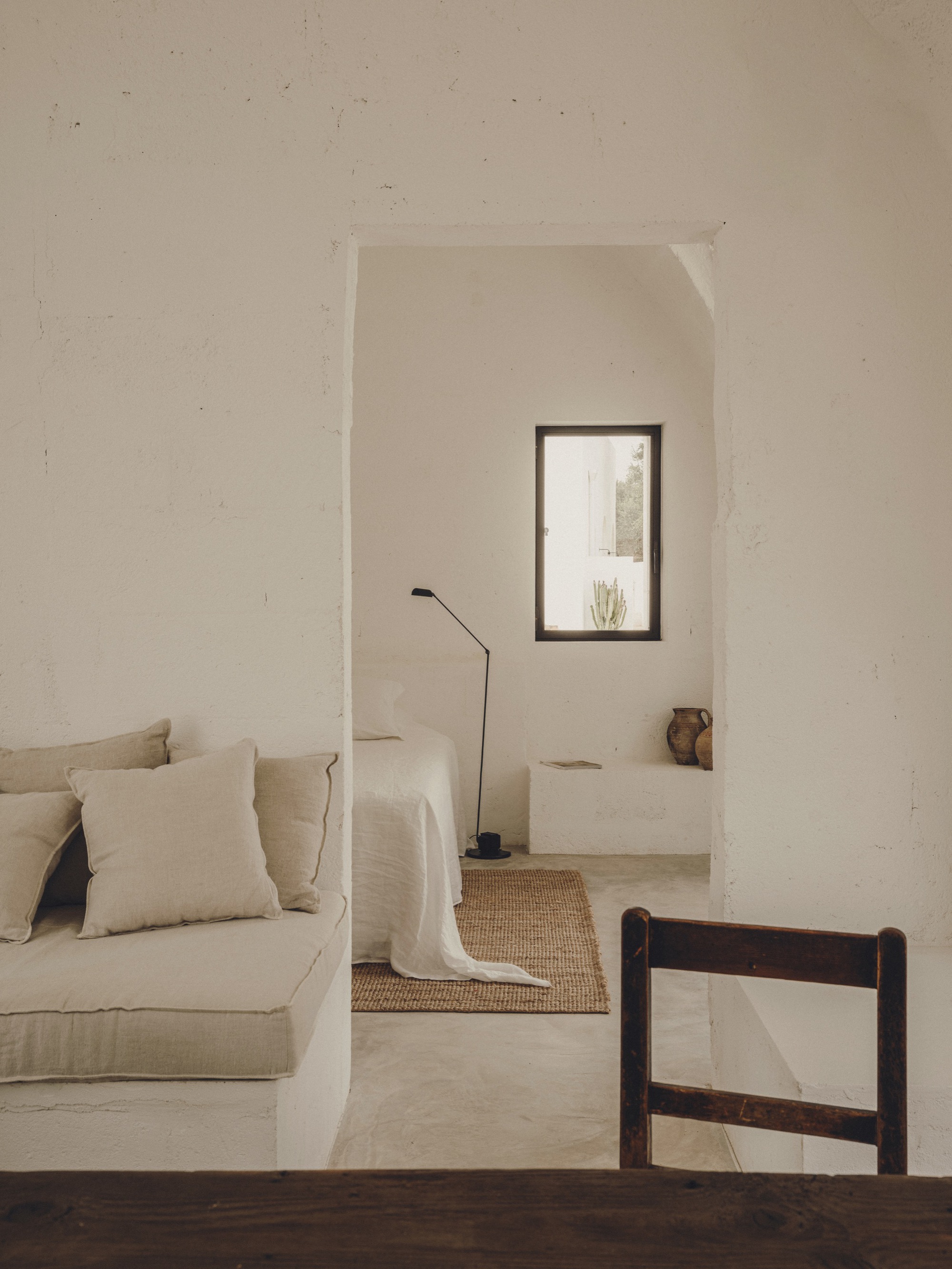 Arched doorway framing a vaulted alcove with portrait window and polished concrete floor in afternoon light