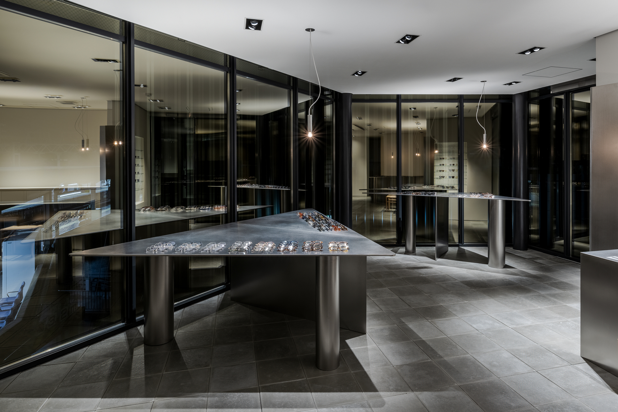 Evening view of the showroom interior with reflections in black glass partition walls