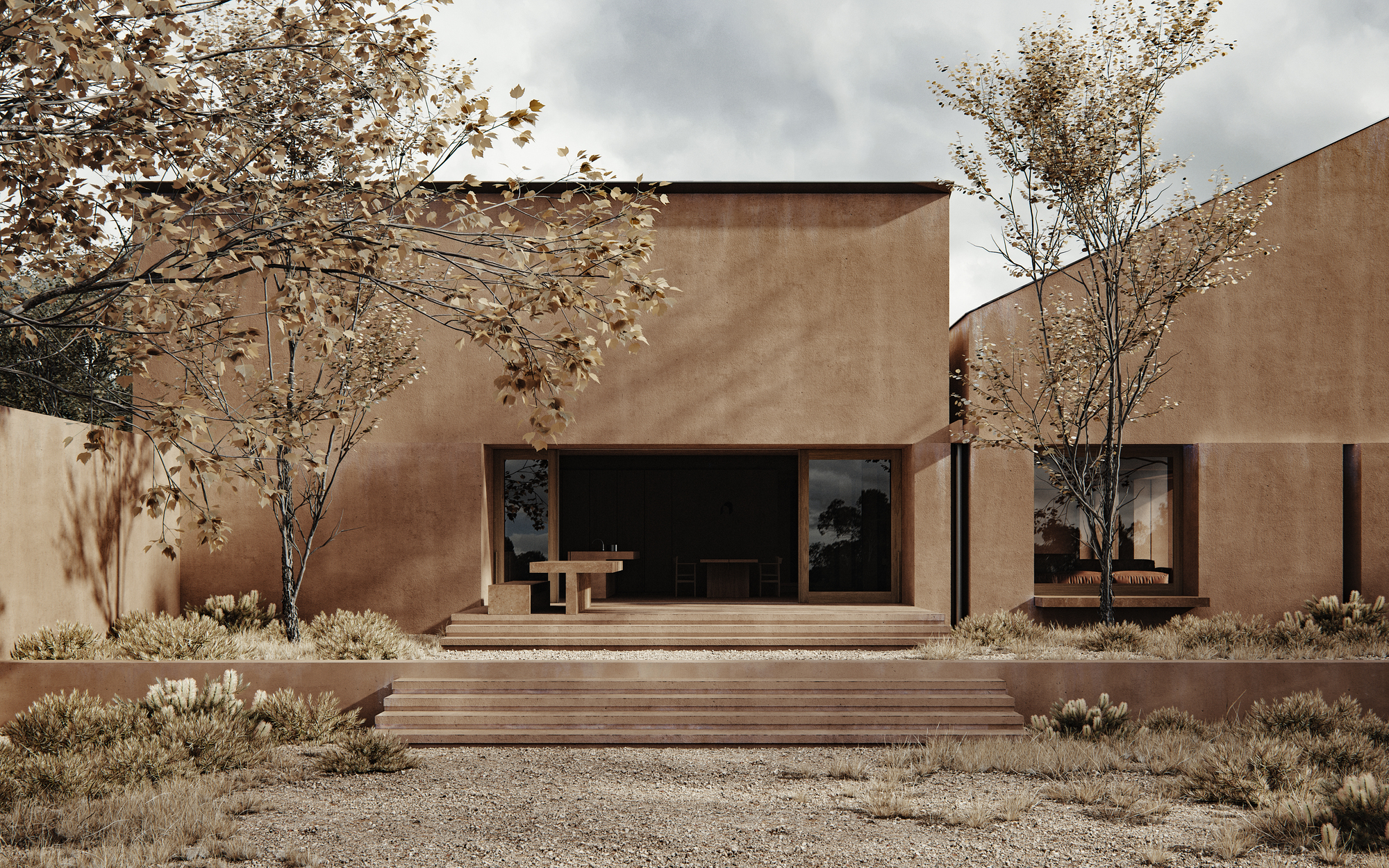 Courtyard view of earth-toned stucco volumes with timber deck and drought-tolerant landscaping under autumn foliage