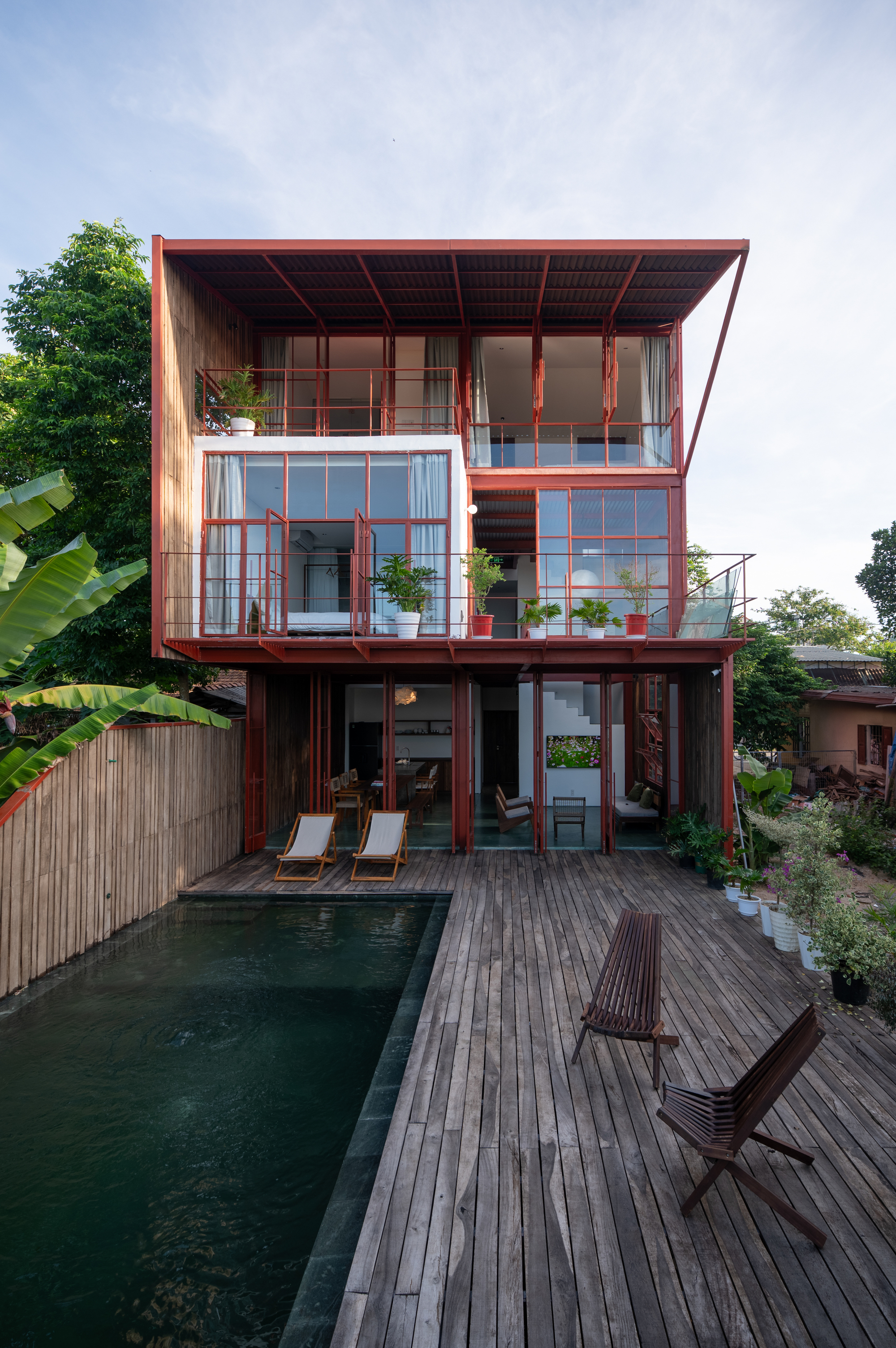 Rear facade showing timber deck with swimming pool and lounge chairs at dusk
