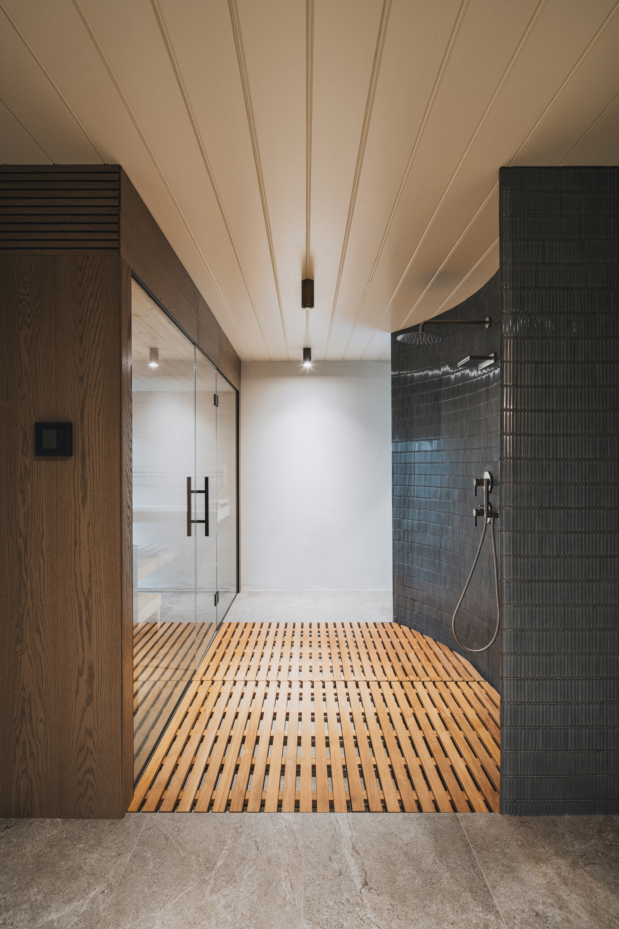 Corridor with timber slatted flooring leading to a glass-walled shower with charcoal tile