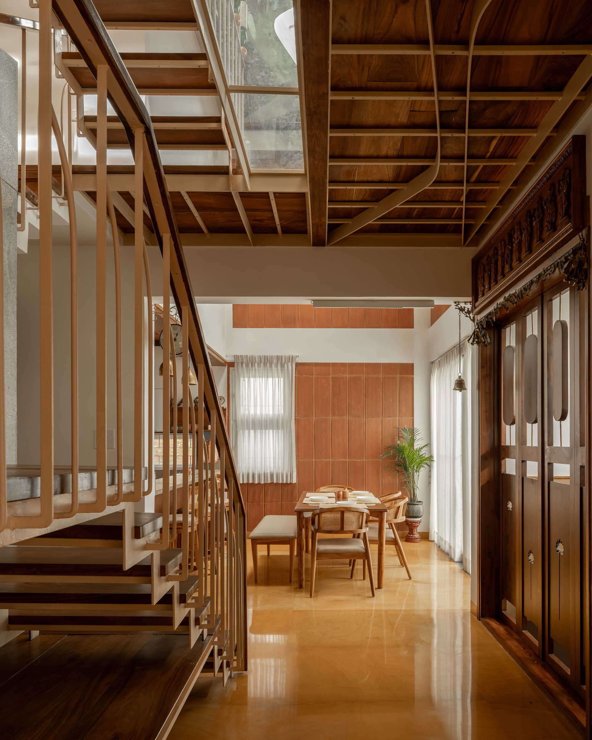 View along the polished floor toward the dining area with timber staircase and exposed ceiling structure