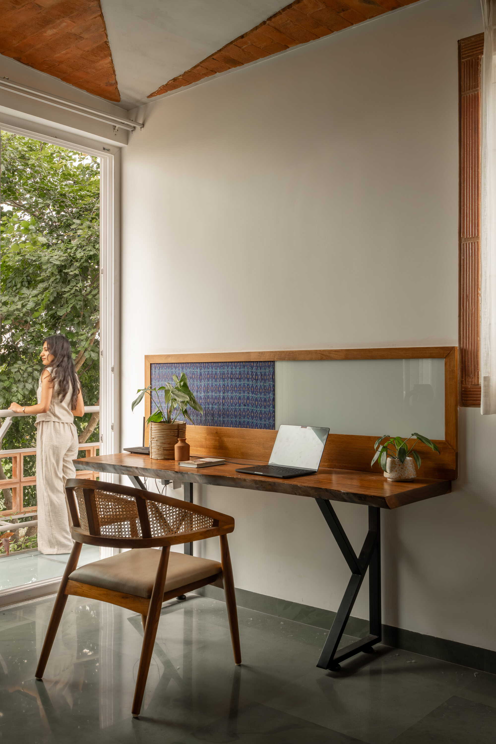 Writing desk alcove with glass and patterned tile backsplash beside a balcony door with garden view