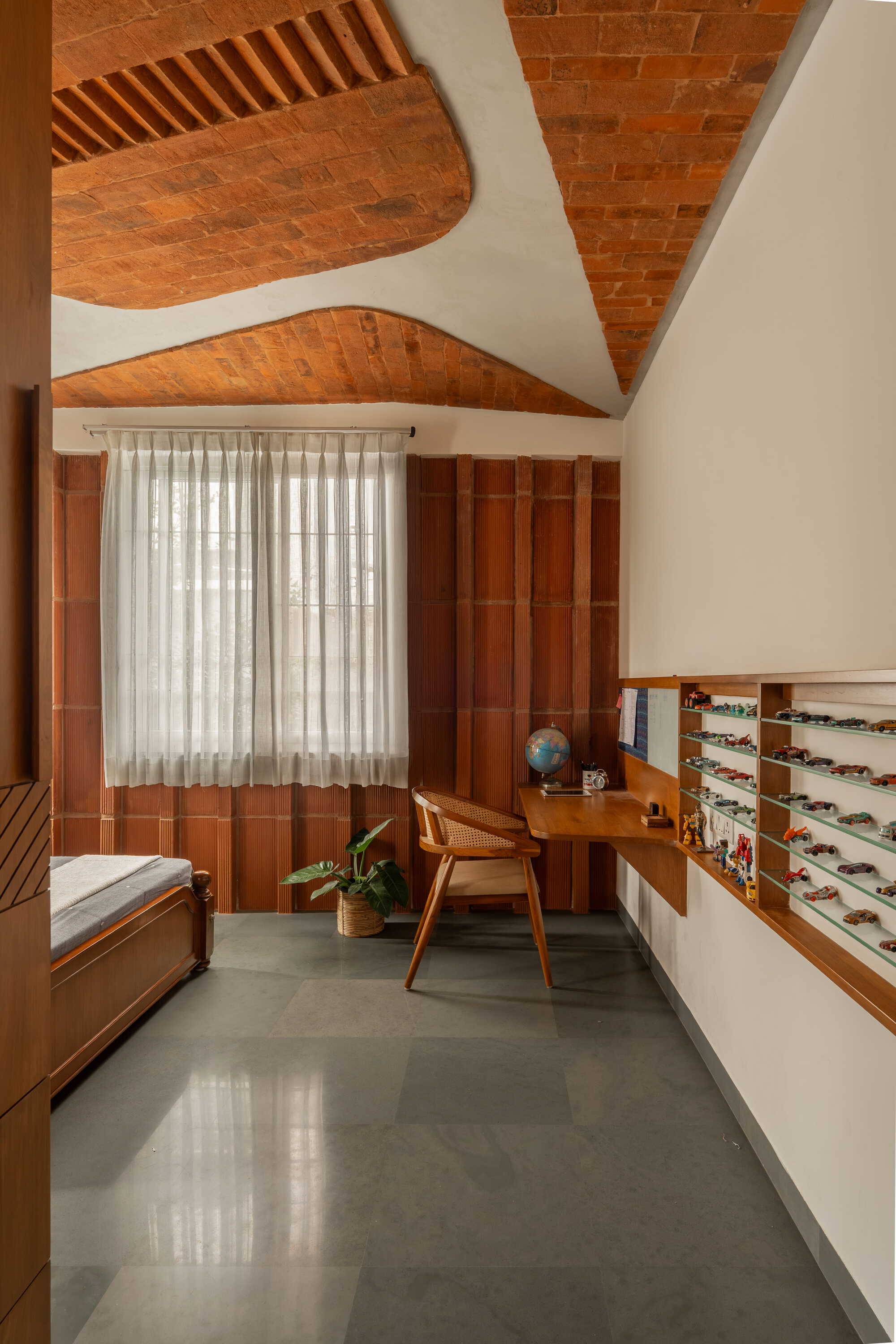 Interior room with vaulted brick ceiling, timber paneled walls, and polished concrete floor in warm daylight