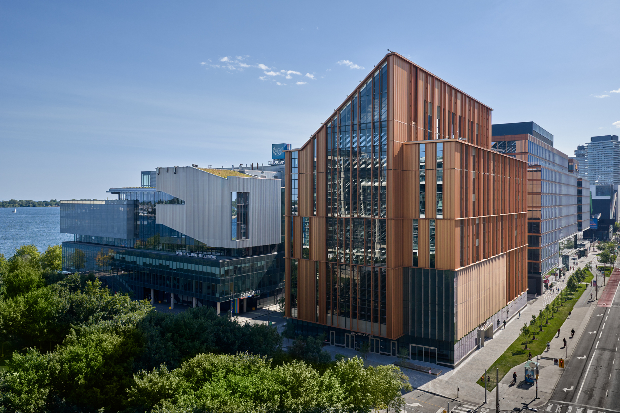 Aerial view of the vertically ribbed copper facade along the waterfront with green trees below