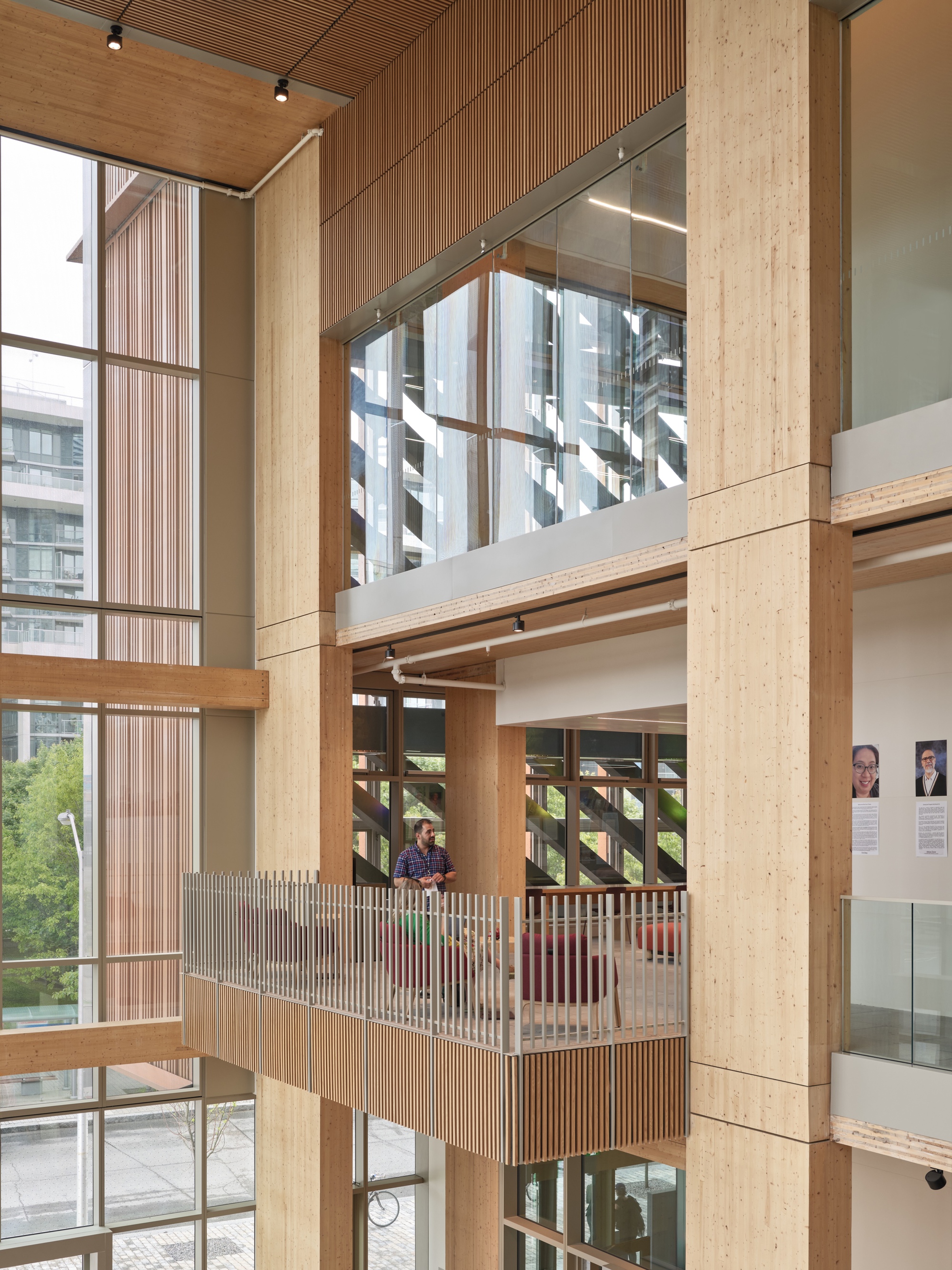 Multi-level interior showing timber balconies with vertical wood slat railings and exposed ceiling beams