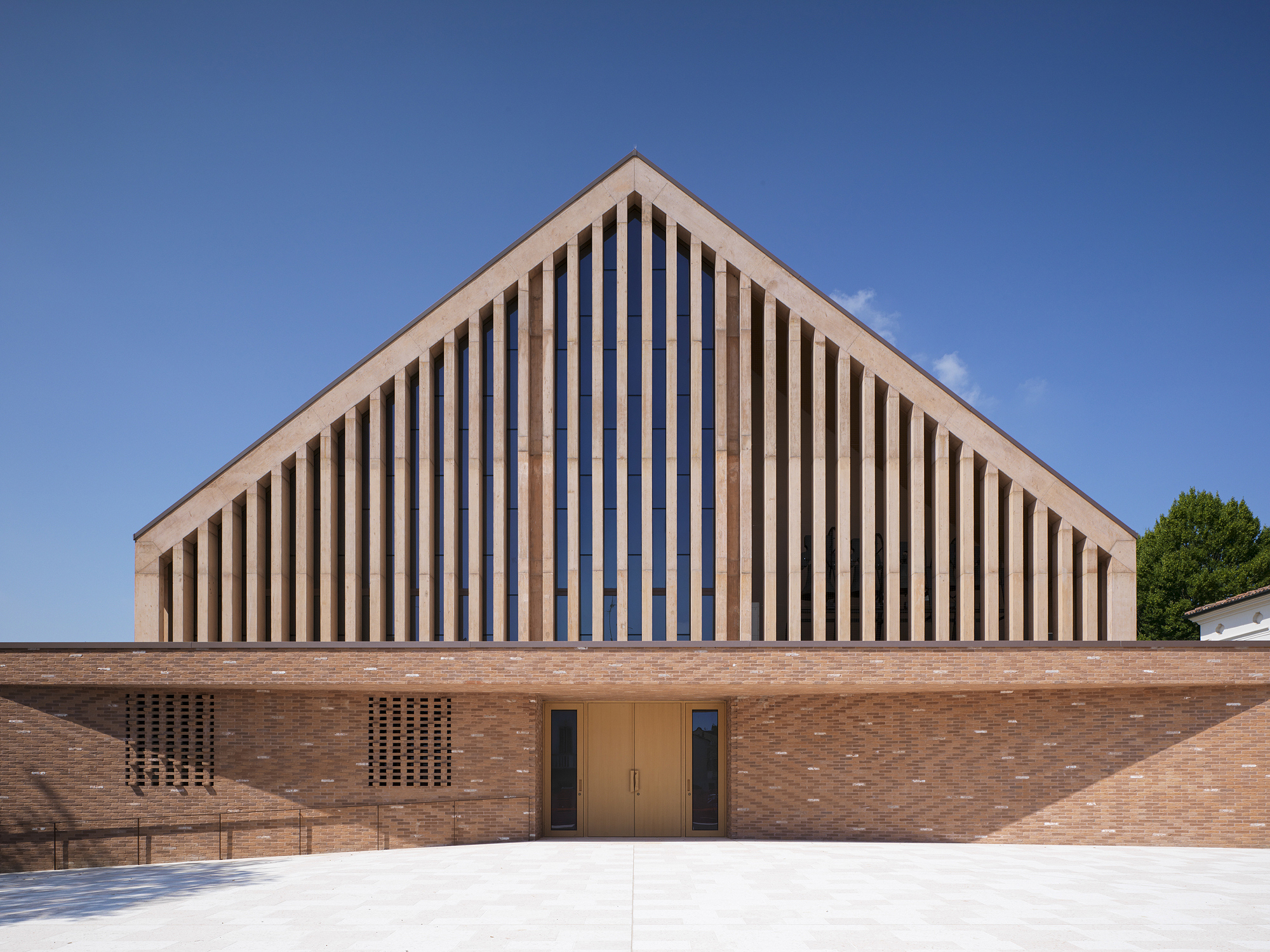 Front elevation showing vertical timber screens framing the entrance doors in a brick facade