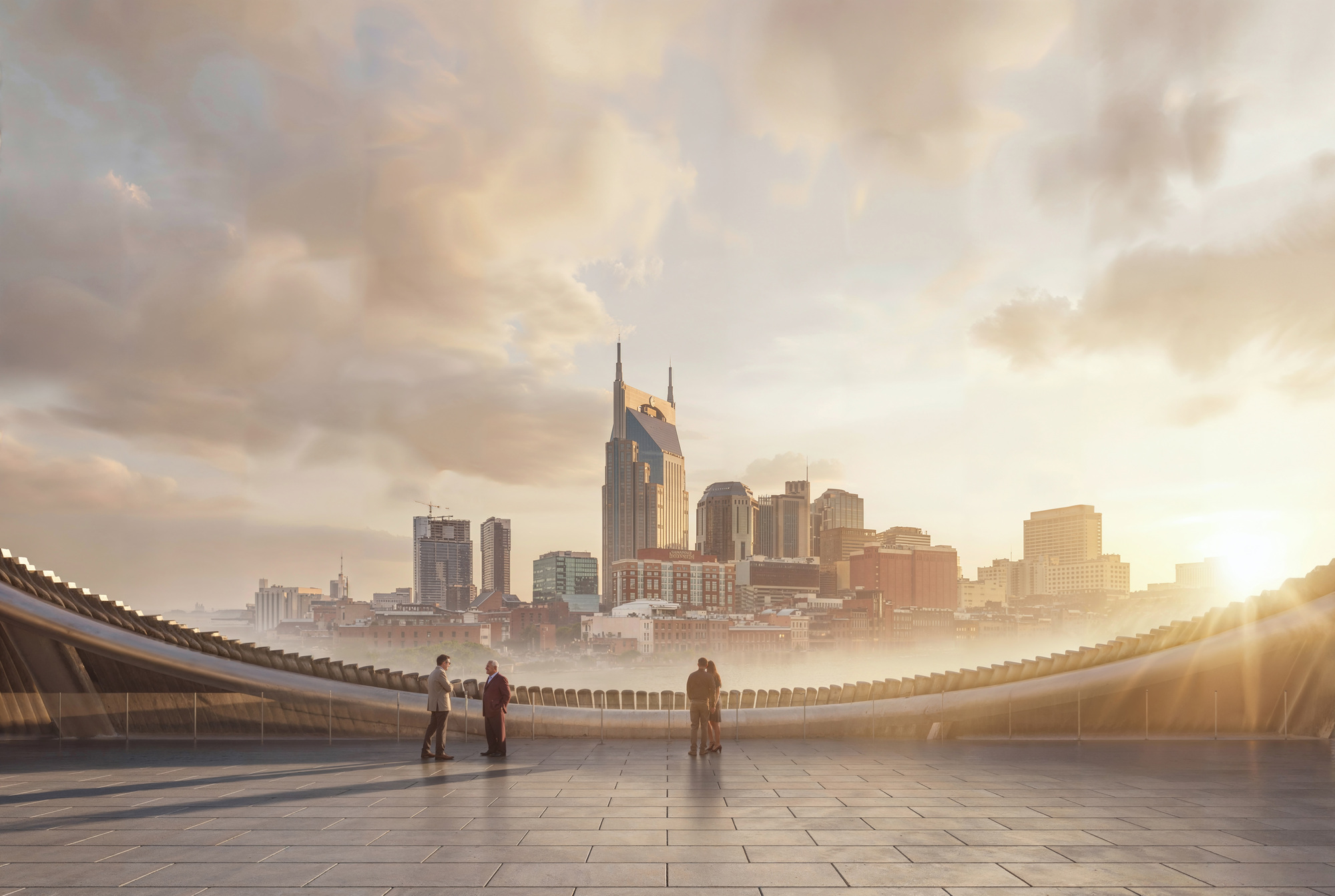 Rooftop terrace with stone pavers and cable railing overlooking a downtown skyline at sunrise