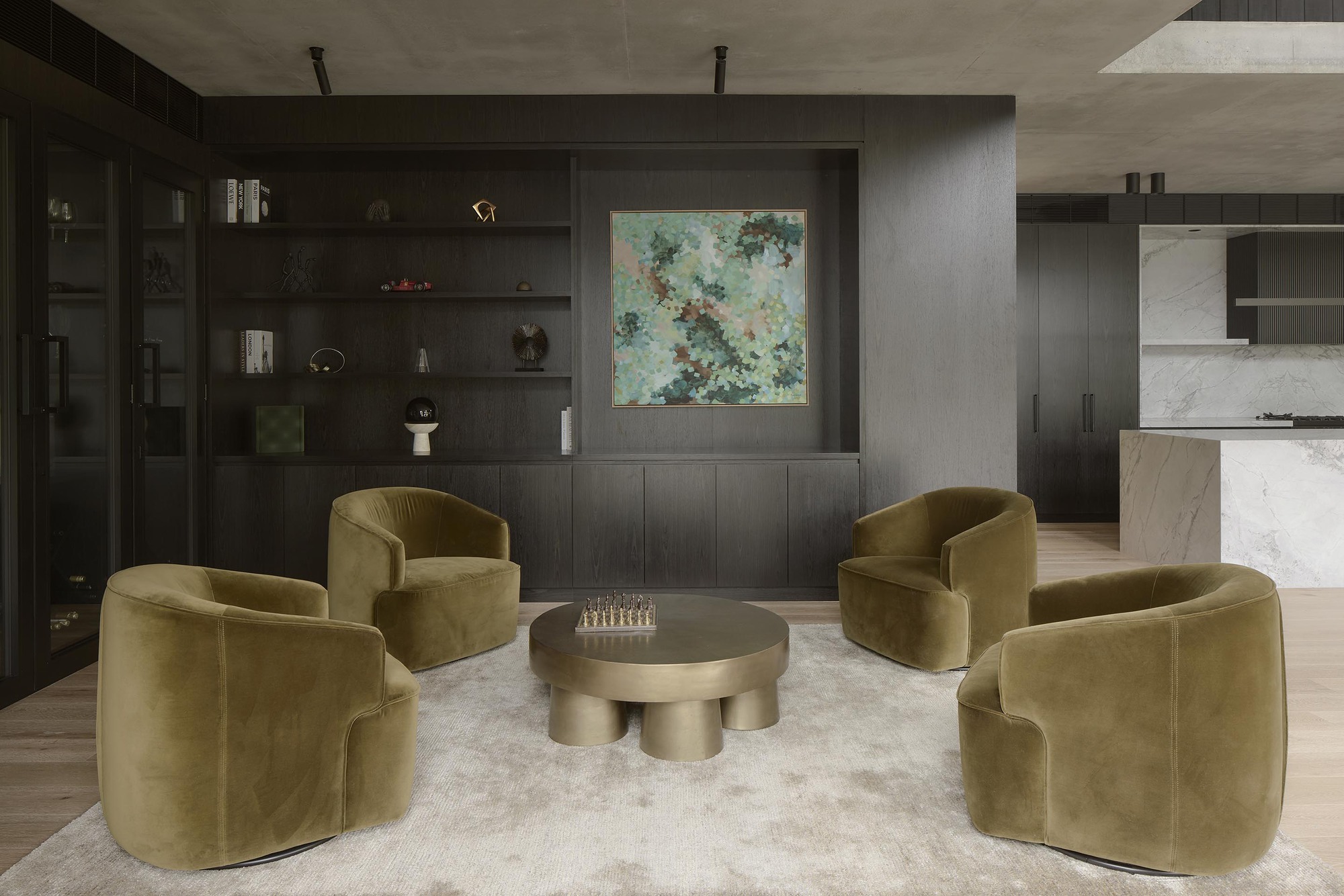 Sitting area with dark timber shelving, concrete ceiling and view through to marble kitchen