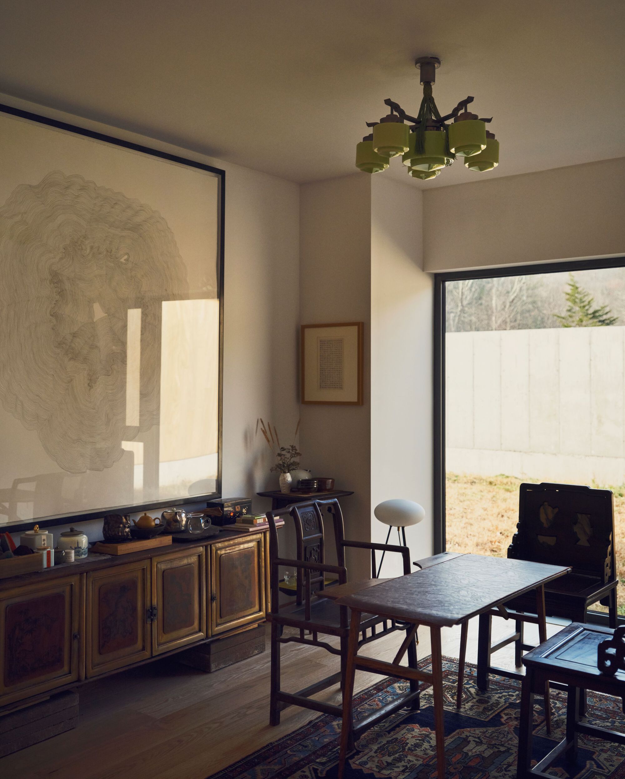 Dining area with corner windows overlooking a walled courtyard in soft morning light