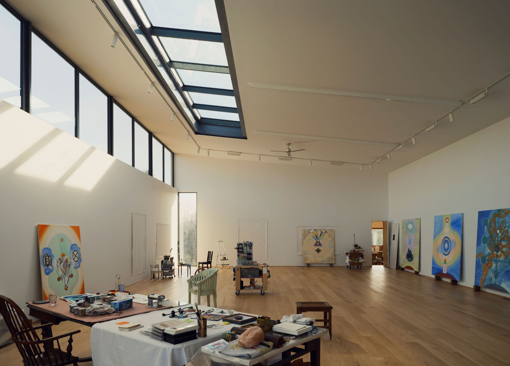 Studio space with clerestory windows and ribbon skylight casting shadows across timber flooring
