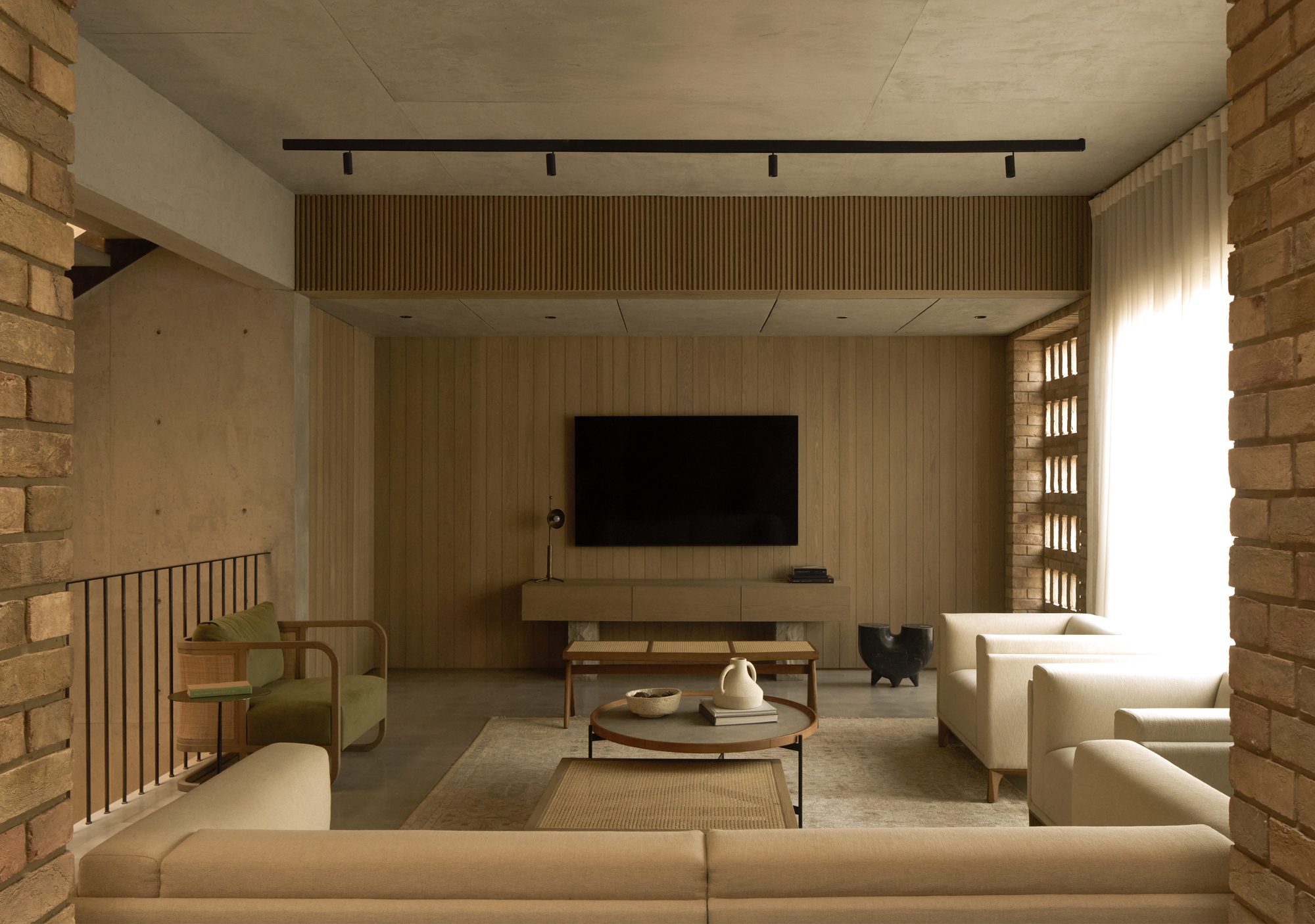 Living space with timber slat wall and perforated brick screen flanking a bright window