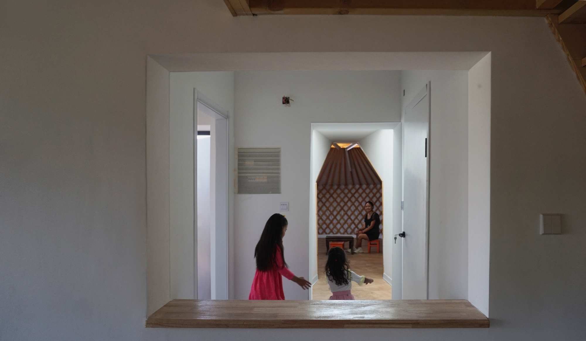 Doorway framing a view through to the yurt interior with its pleated fabric ceiling and lattice walls