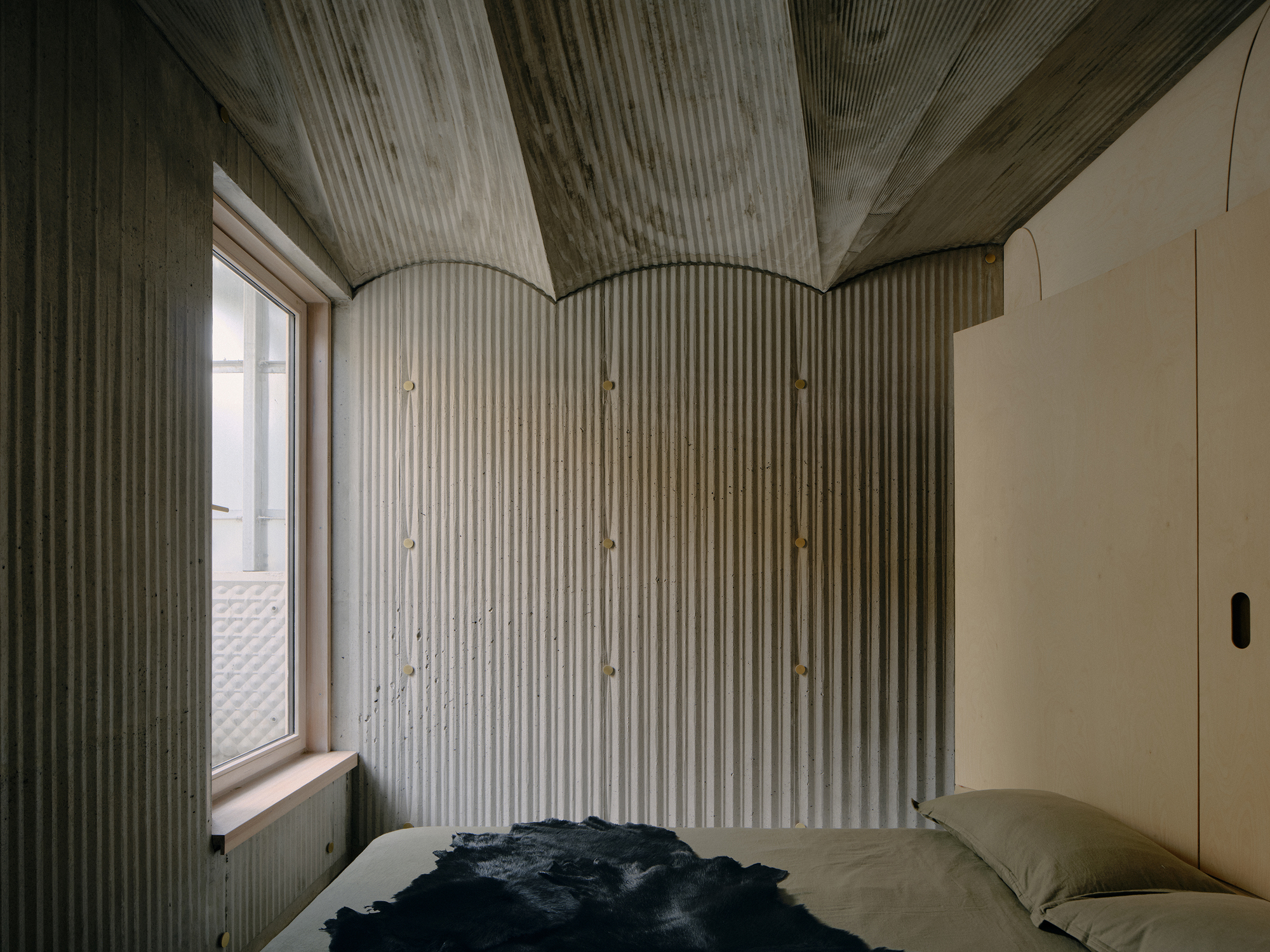 Bedroom corner with ribbed wall paneling meeting the curved vault ceiling at three arched ceiling joins
