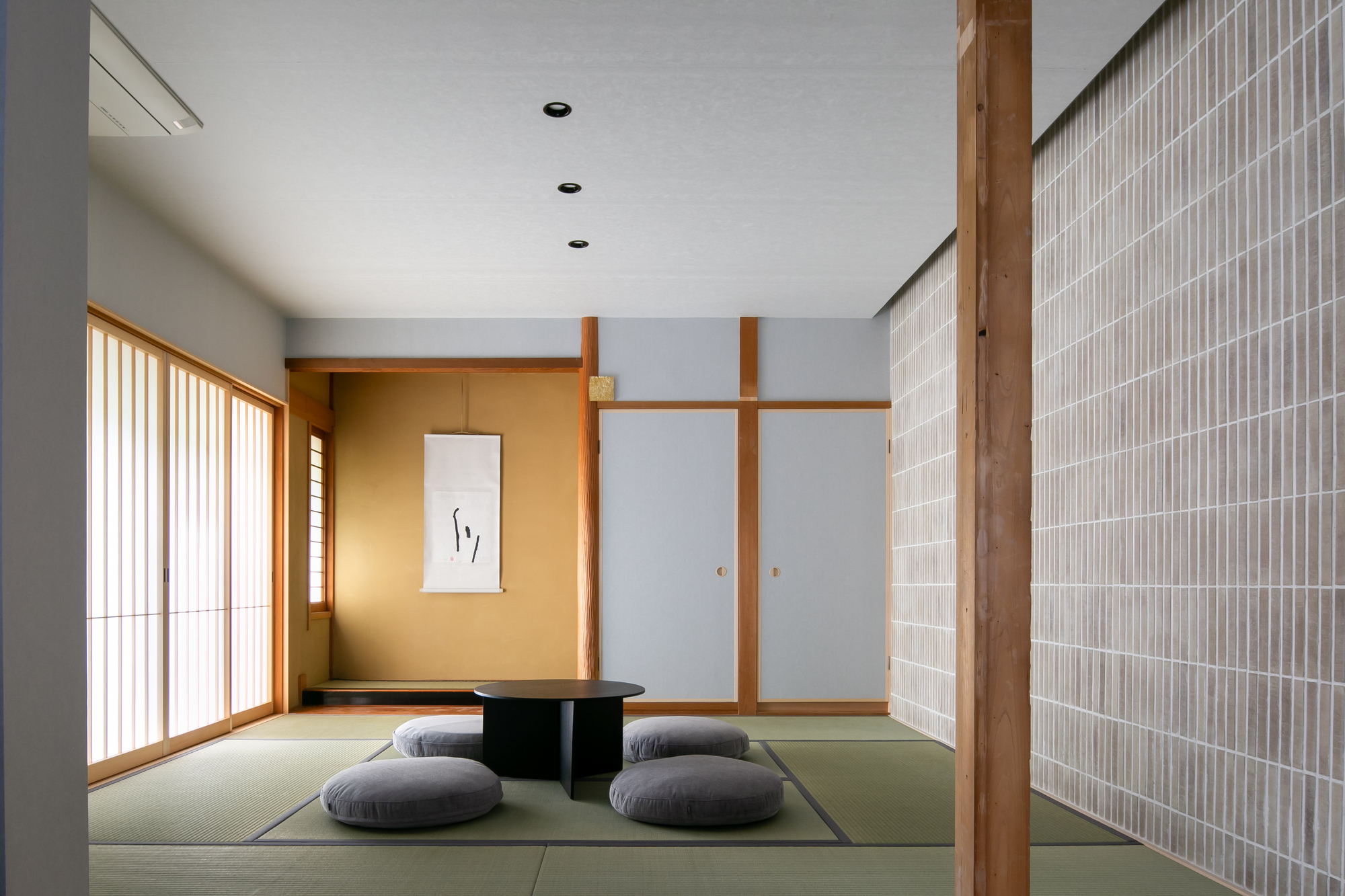 Tatami room with sliding screens and timber column alongside a vertical slatted partition wall