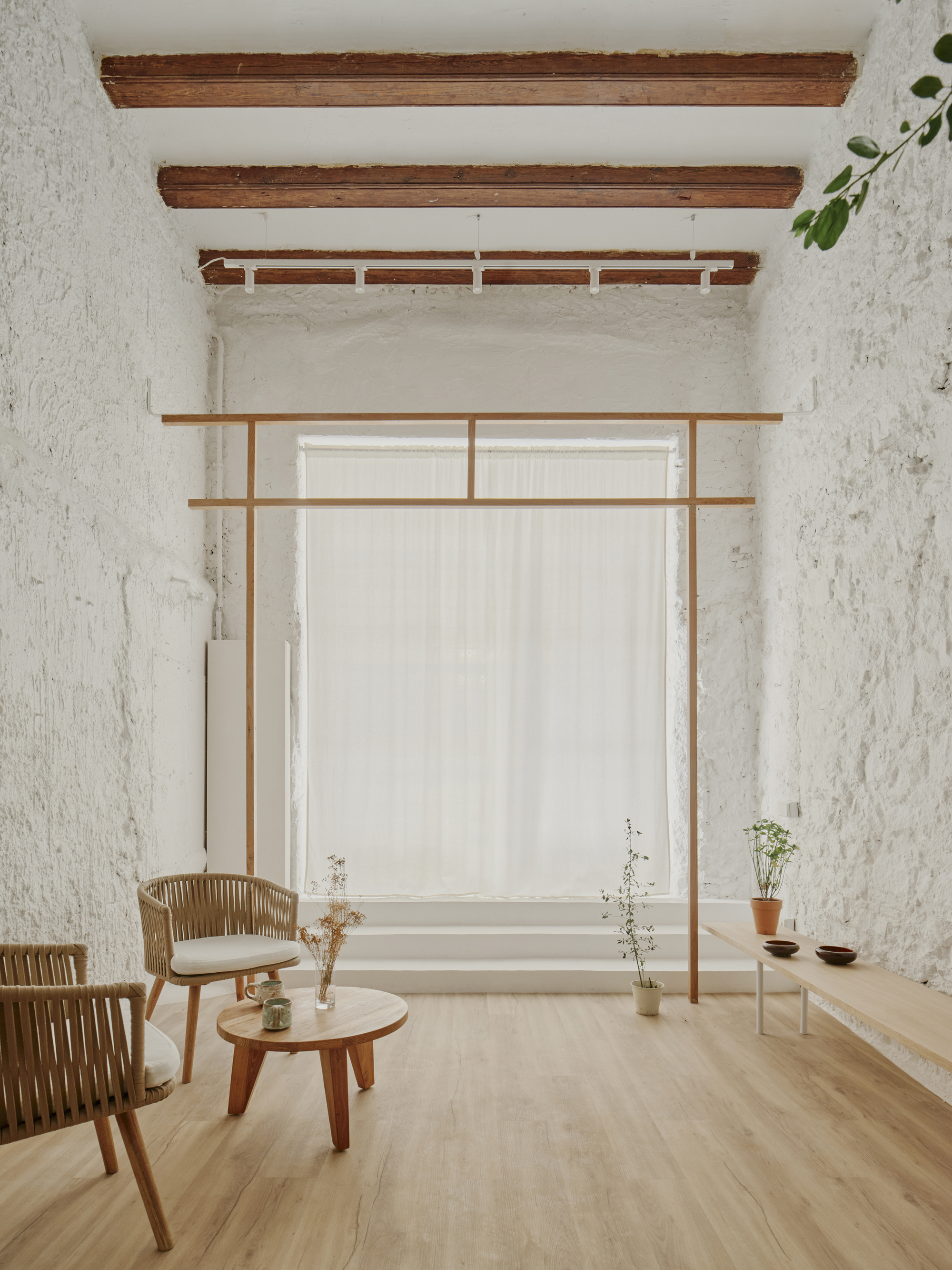 Sitting area with timber frame structure beneath exposed ceiling beams and white render walls