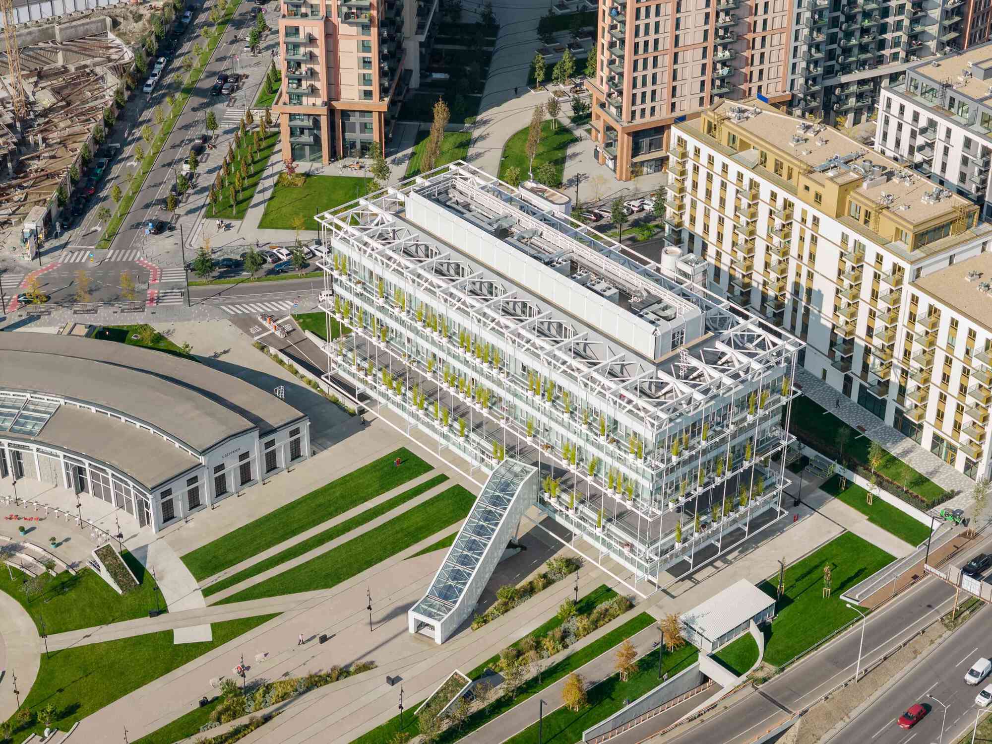 Aerial view of the white steel-framed greenhouse structure surrounded by lawns and residential towers