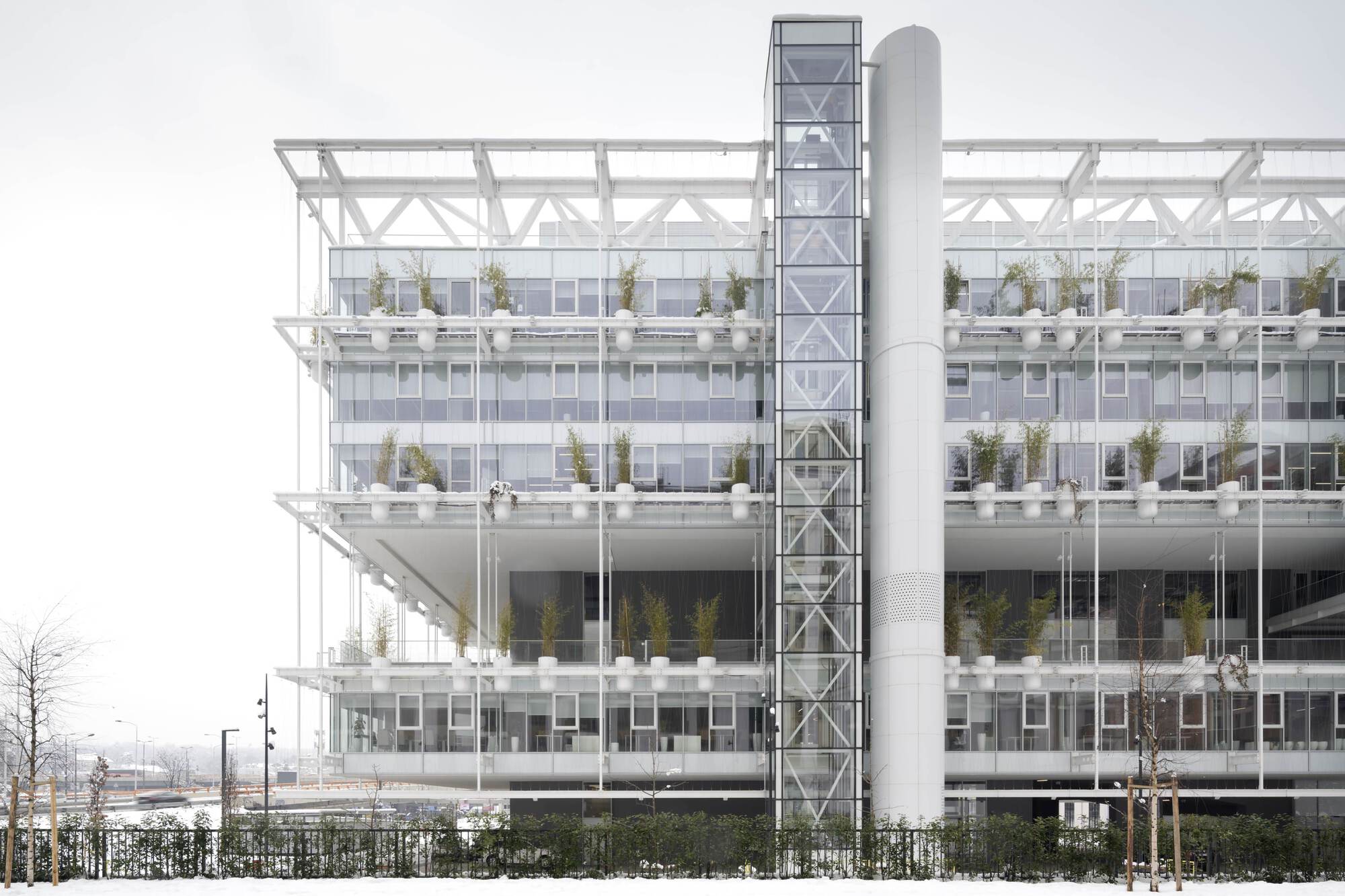 Elevation showing the white structural frame with planted terraces on each level during winter