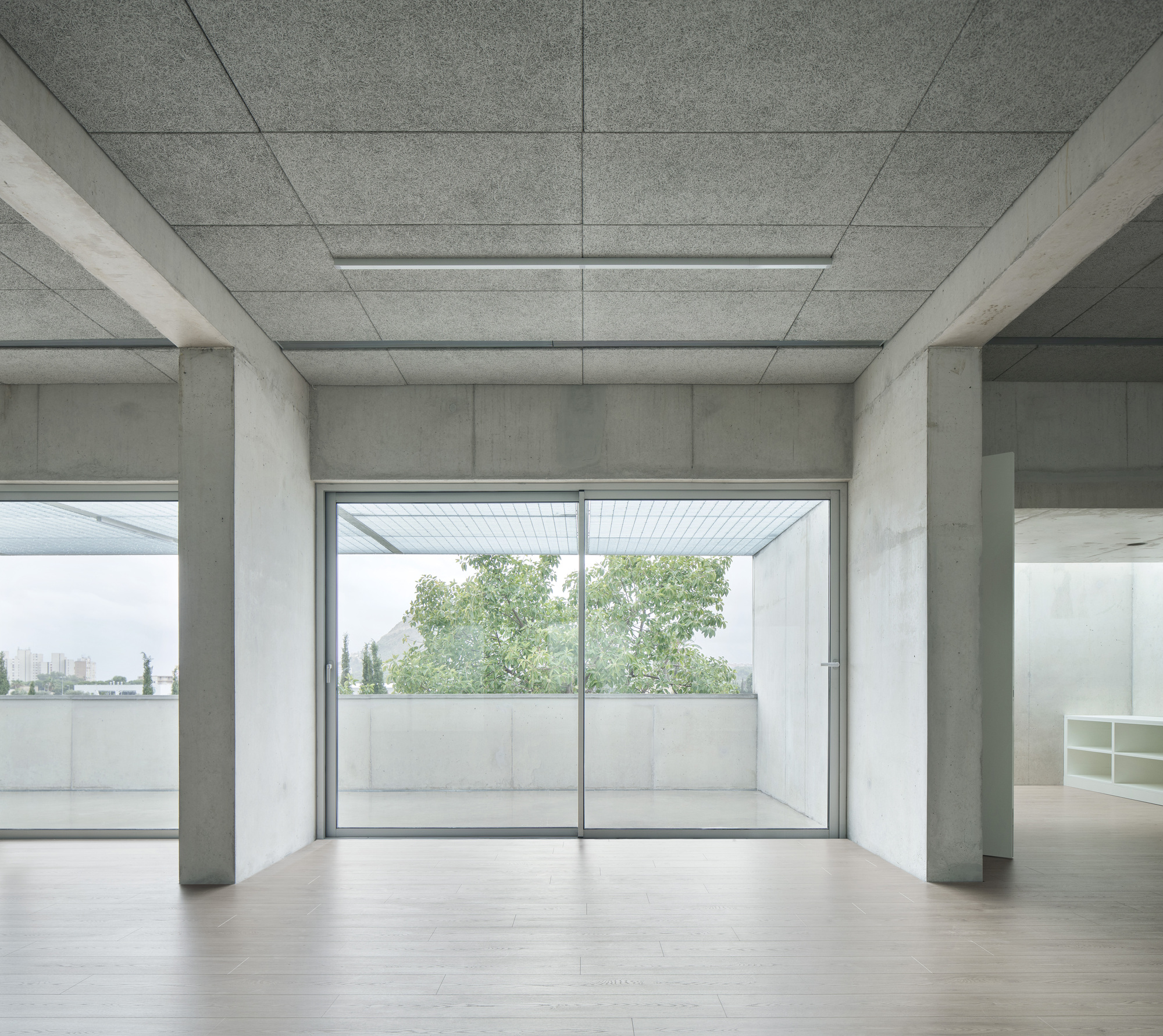Room with paneled concrete ceiling and sliding glass doors opening to a terrace